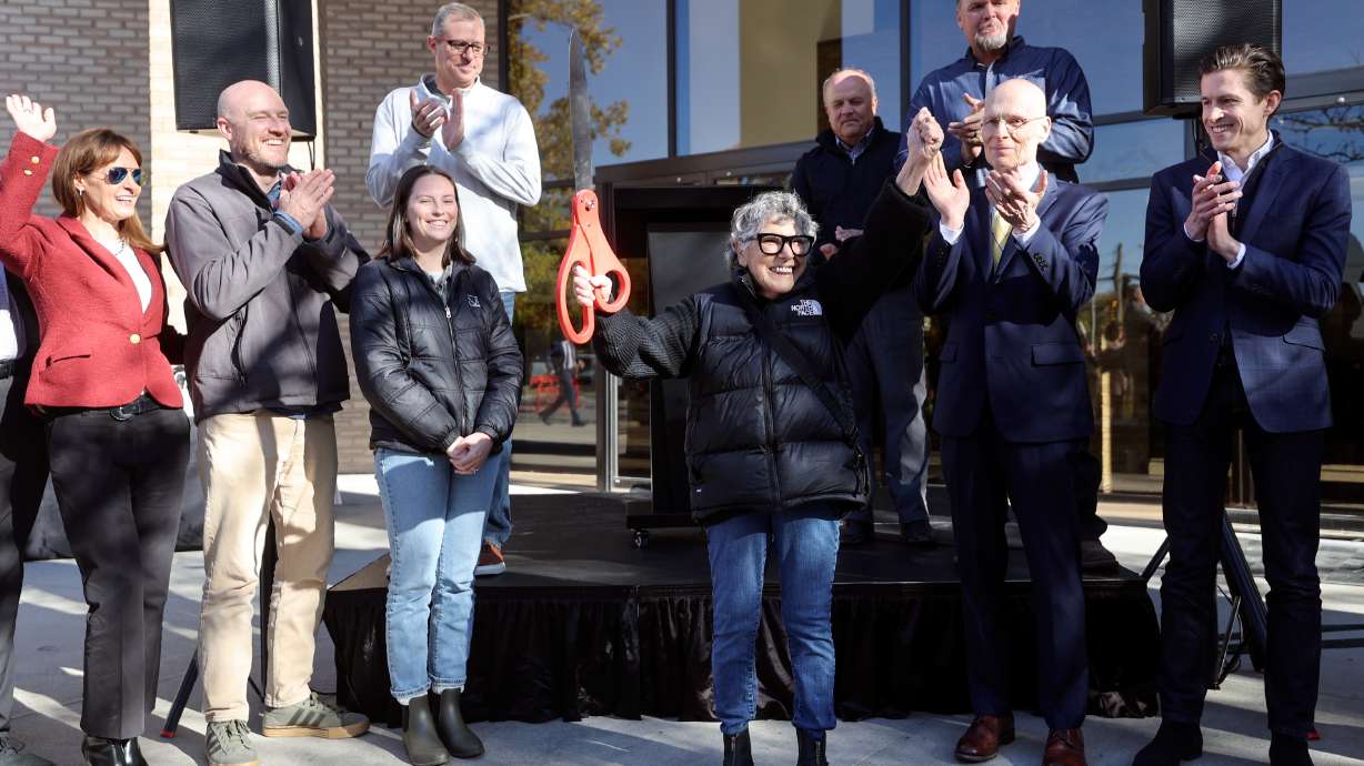 Tena Holbrook, an Arbor 515 resident, celebrates a ribbon-cutting ceremony at Arbor 515, a new affordable housing project, in Salt Lake City on Thursday. The project converted the 515 Tower office building into 96 affordable housing units.