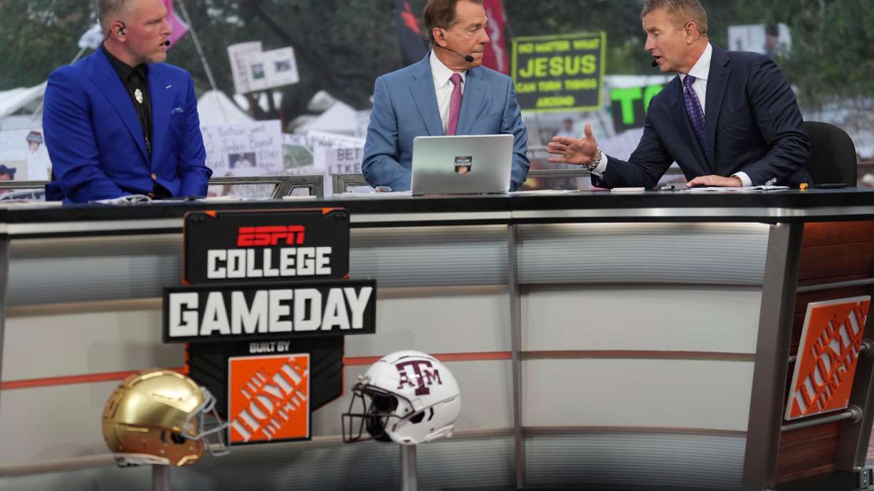 FILE - From left, Pat Mcafee, Nick Saban and Kirk Herbstreit talk on the set of ESPN College Gameday on Saturday, Aug. 31, 2024, in College Station, Texas.