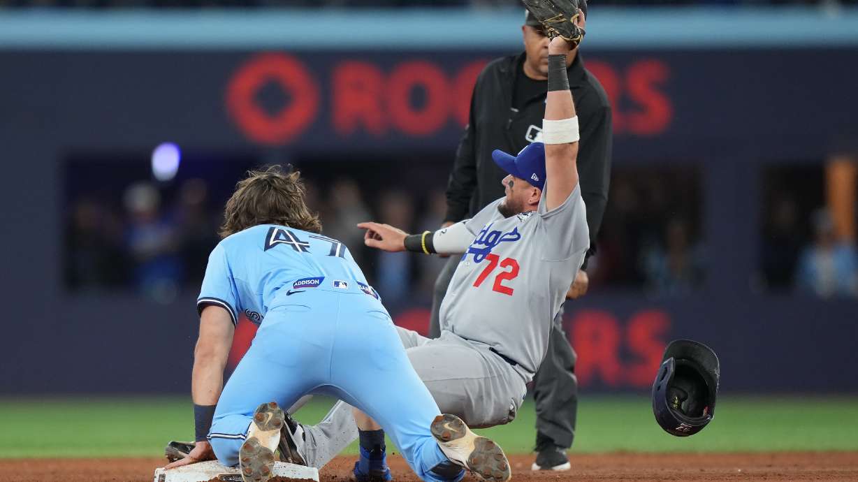 Los Angeles Dodgers second baseman Miguel Rojas (72) shows the ball to the umpire after forcing out Toronto Blue Jays' Addison Barger (47) at second to turn a double play to end the game during ninth inning Game 6 World Series playoff MLB baseball action in Toronto on Friday, Oct. 31, 2025.