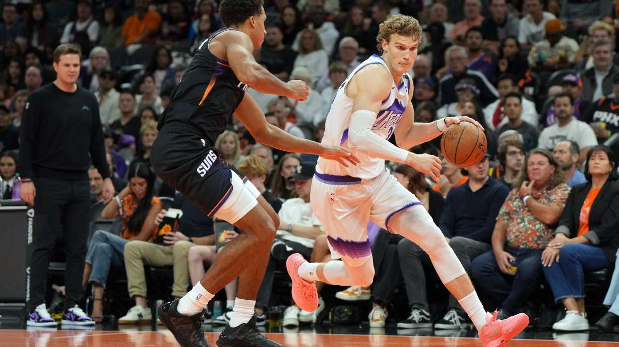 Utah Jazz forward/center Lauri Markkanen (23) drives around Phoenix Suns forward Oso Ighodaro (11) during the second half of an NBA Cup basketball game, Friday, Oct. 31, 2025, in Phoenix.