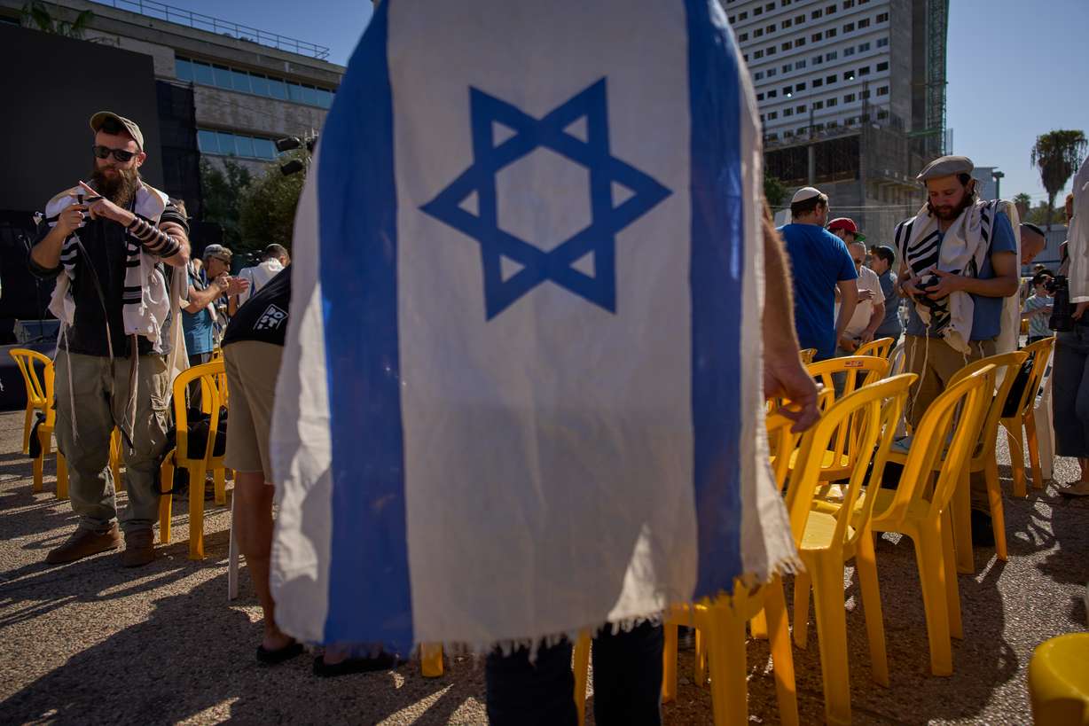 People attend a tefillin-laying ceremony, led by freed hostage Bar Kupershtein, at Hostages Square, in Tel Aviv, Israel, Friday. The ceasefire in the Gaza war is under strain as both sides trade accusations of violations.