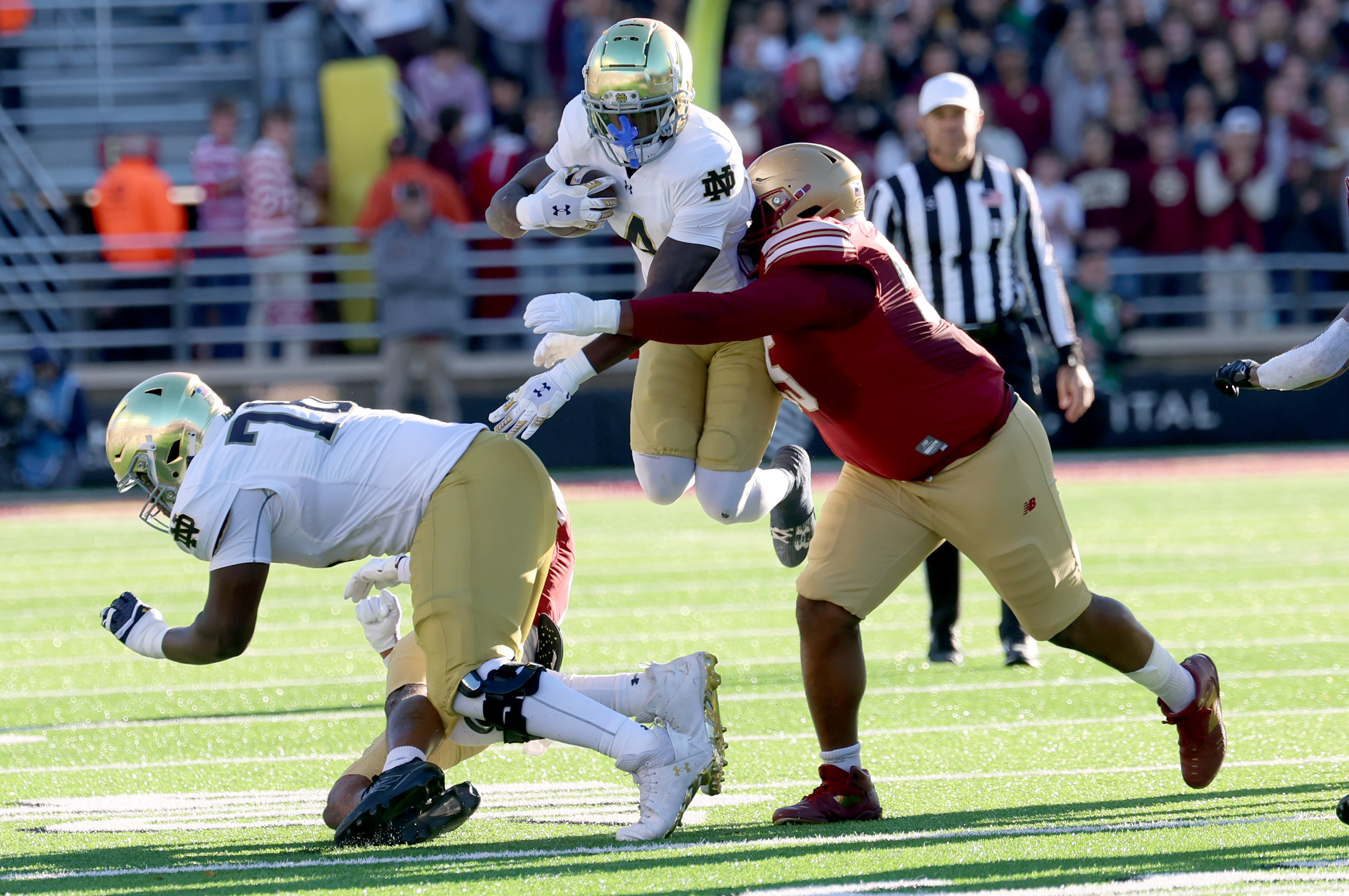 Notre Dame running back Jeremiyah Love, center, is grabbed and tackled by Boston College defensive lineman Kwan Williams, right, during the first half of an NCAA college football game Saturday, Nov. 1, 2025 in Boston. 
