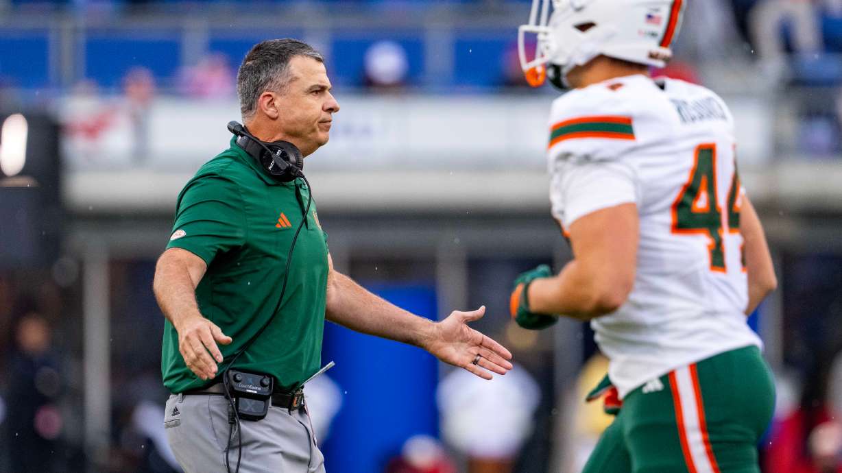 Miami head coach Mario Cristobal greets players as they come off the field during the first half of an NCAA college football game against SMU, Saturday, Nov. 1, 2025, in Dallas.