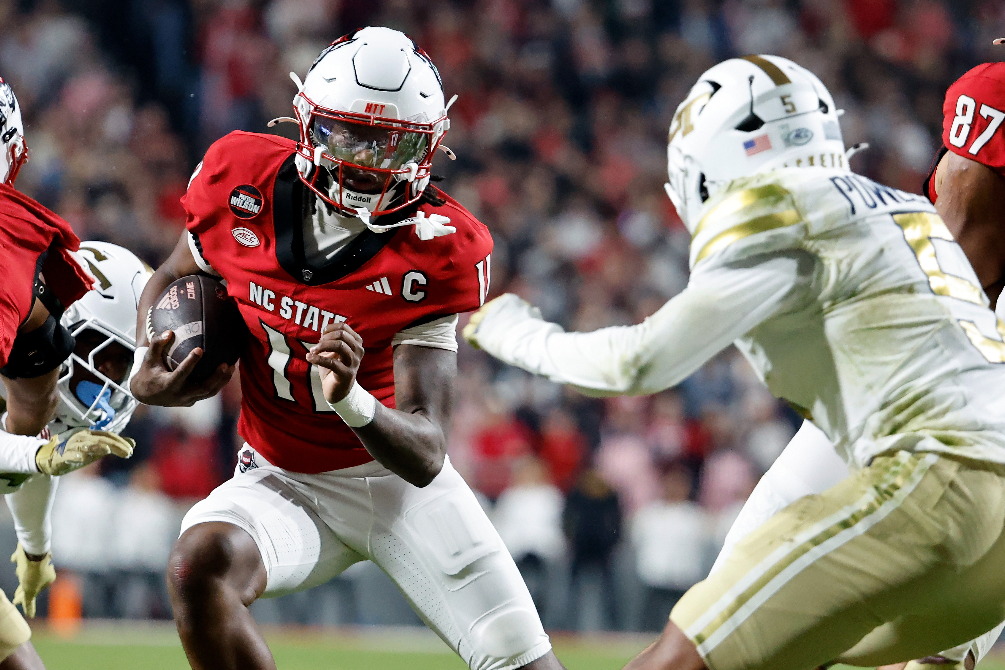 North Carolina State quarterback CJ Bailey (11) runs the ball as Georgia Tech's Clayton Powell-Lee (5) closes in during the first half of an NCAA college football game in Raleigh, N.C., Saturday, Nov. 1, 2025. 