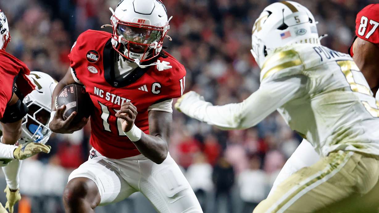 North Carolina State quarterback CJ Bailey (11) runs the ball as Georgia Tech's Clayton Powell-Lee (5) closes in during the first half of an NCAA college football game in Raleigh, N.C., Saturday, Nov. 1, 2025.