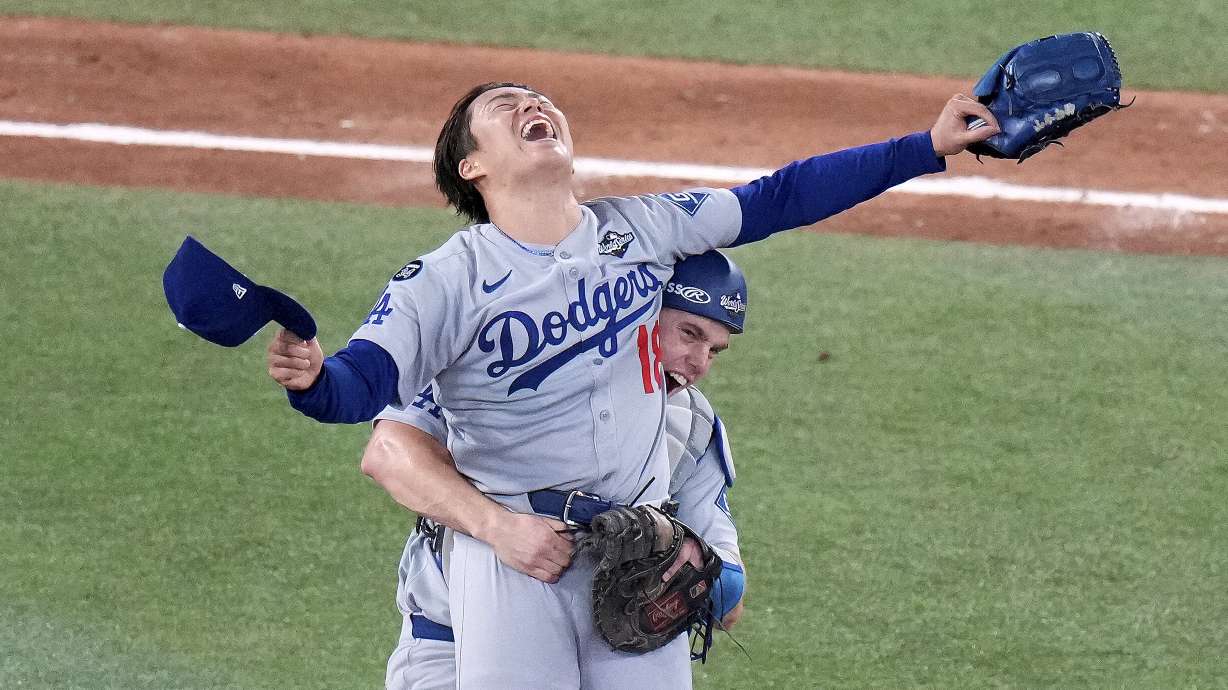 Los Angeles Dodgers pitcher Yoshinobu Yamamoto (18) celebrates with teammate Will Smith after the team defeated the Toronto Blue Jays in Game 7 of baseball's World Series, Sunday, Nov. 2, 2025, in Toronto.