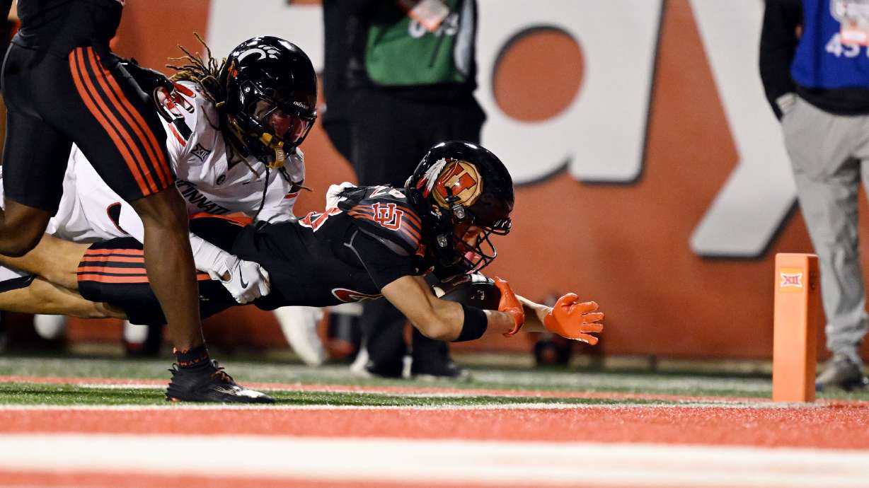 Utah Utes wide receiver Mana Carvalho (28) carries Cincinnati Bearcats defensive back Kye Stokes (3) into the endzone for punt return for touchdown as Utah and Cincinnati play at Rice Eccles Stadium in Salt Lake City on Saturday, Nov. 1, 2025.
