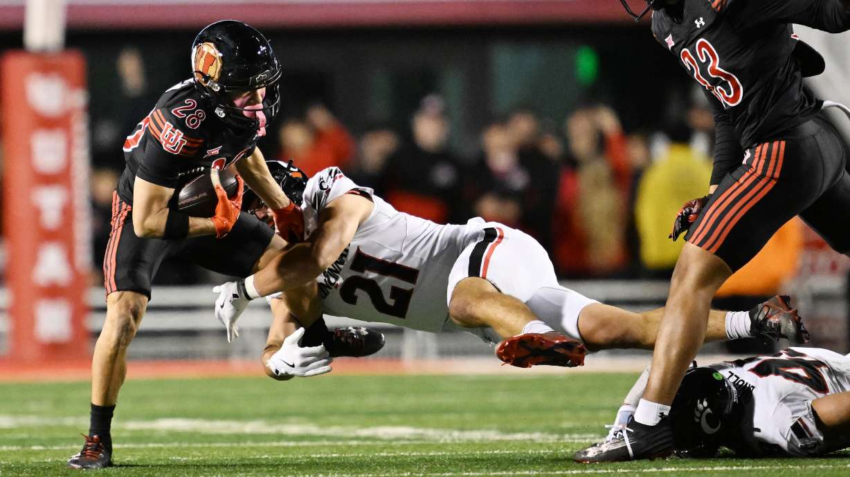 Utah Utes wide receiver Mana Carvalho (28) fights to shed Cincinnati Bearcats defensive lineman C.J. McCray (21) as Utah and Cincinnati play at Rice Eccles Stadium in Salt Lake City on Saturday, Nov. 1, 2025.