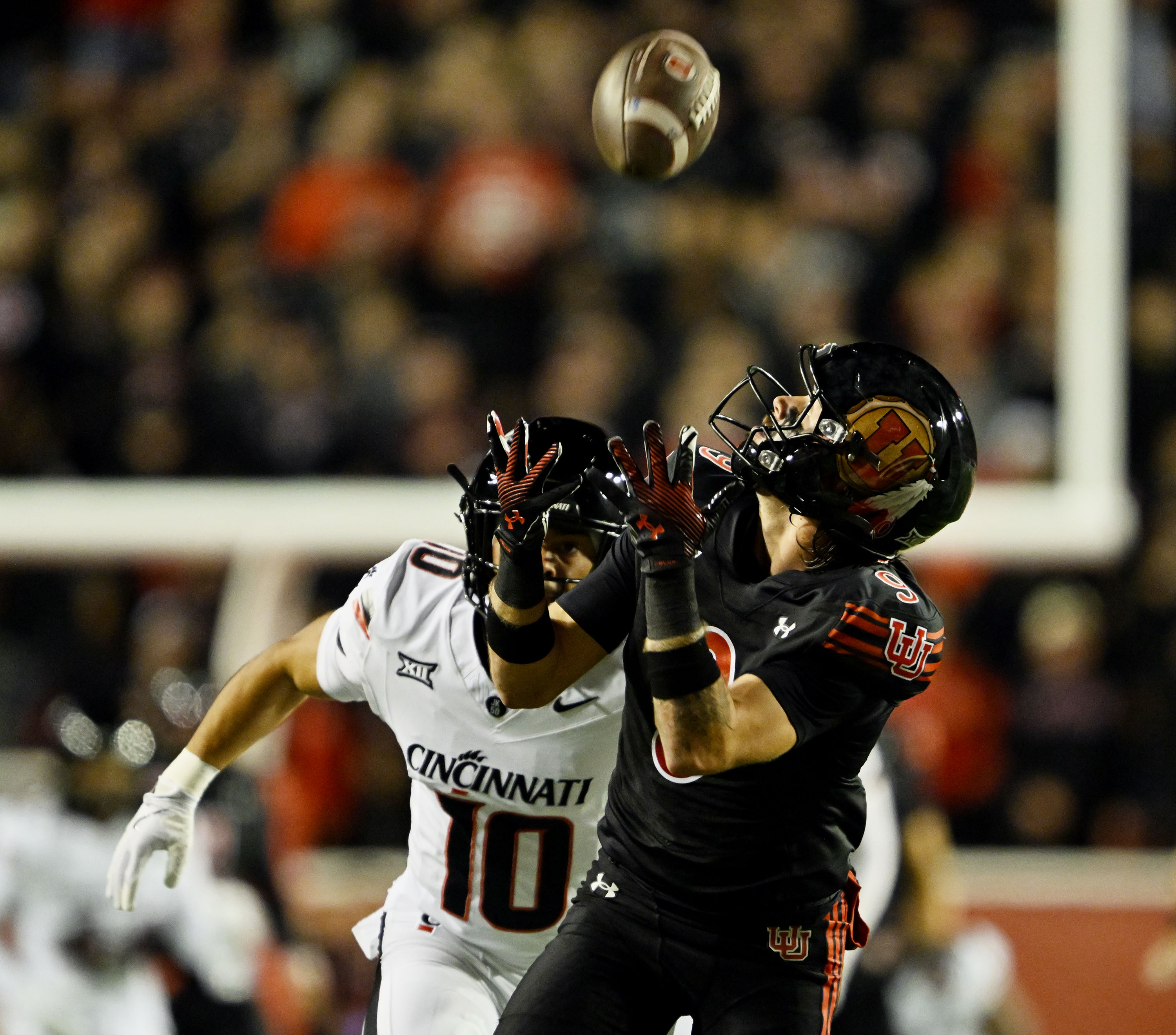Utah Utes wide receiver Ryan Davis (9) reaches up for the ball as he makes a catch for a long gain downfield with Cincinnati Bearcats safety Tayden Barnes (10) trying to make the tackle as Utah and Cincinnati play at Rice-Eccles Stadium in Salt Lake City on Saturday, Nov. 1, 2025.