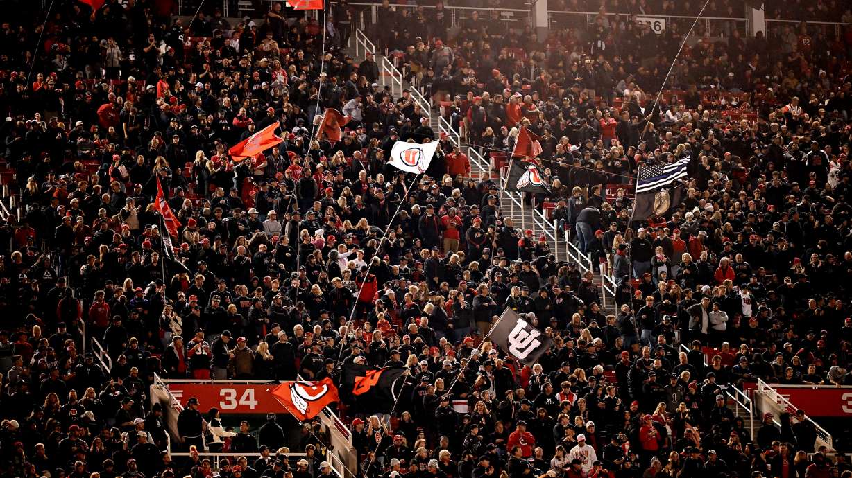Fans cheer and wave flags as Utah and Cincinnati play at Rice-Eccles Stadium in Salt Lake City on Saturday, Nov. 1, 2025.