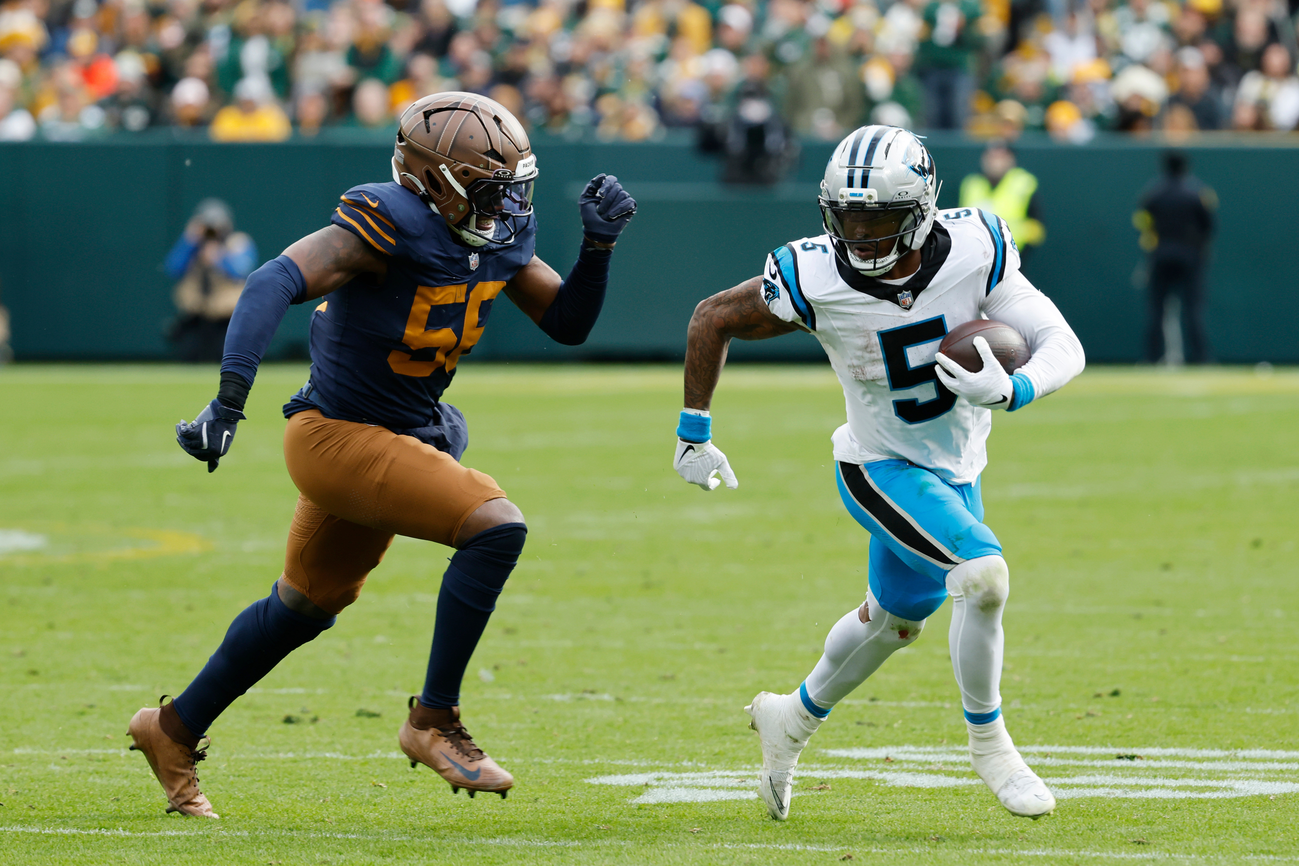 Carolina Panthers running back Rico Dowdle (5) runs against Green Bay Packers defensive end Kingsley Enagbare (55) during the second half of an NFL football game Sunday, Nov. 2, 2025, in Green Bay, Wis. 