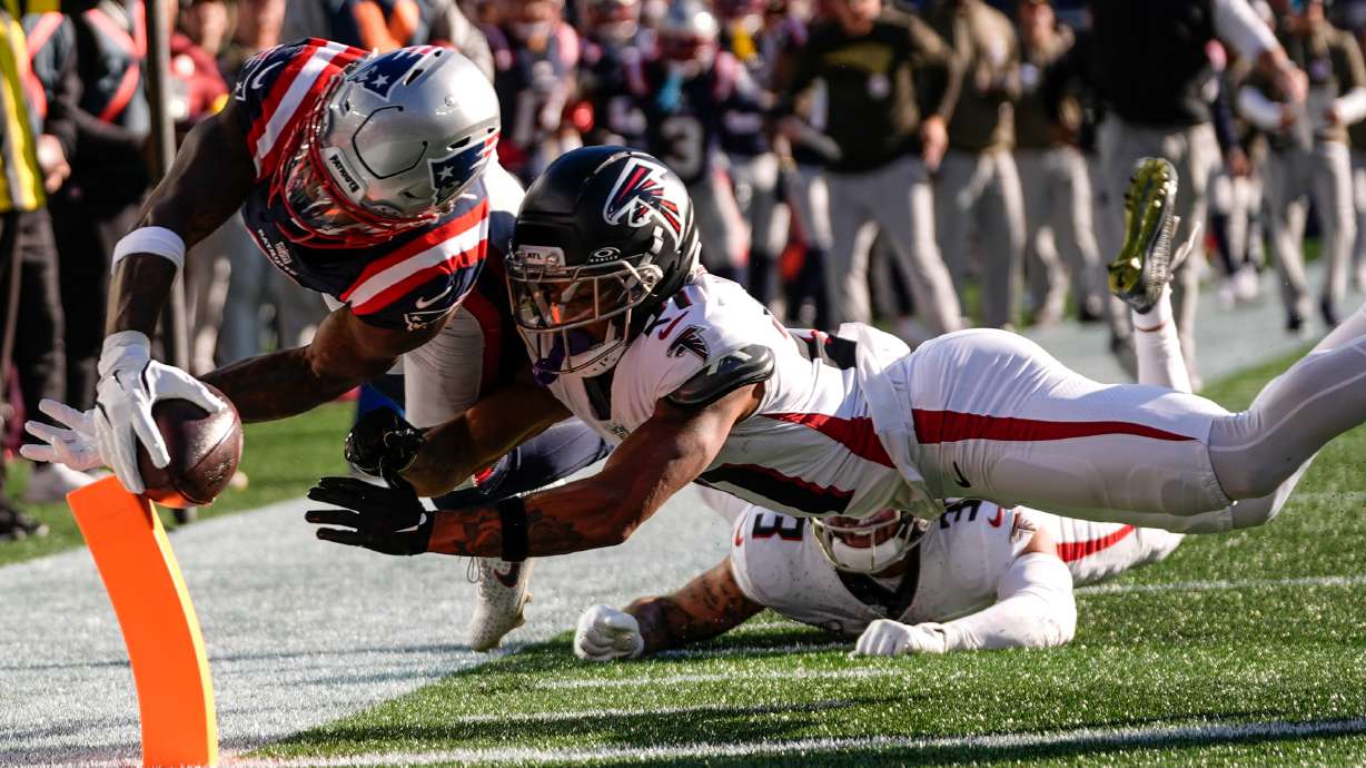 New England Patriots wide receiver Stefon Diggs (8) scores a touchdown against Atlanta Falcons cornerback Mike Hughes (21) during the first half of an NFL football game, Sunday, Nov. 2, 2025, in Foxborough, Mass.