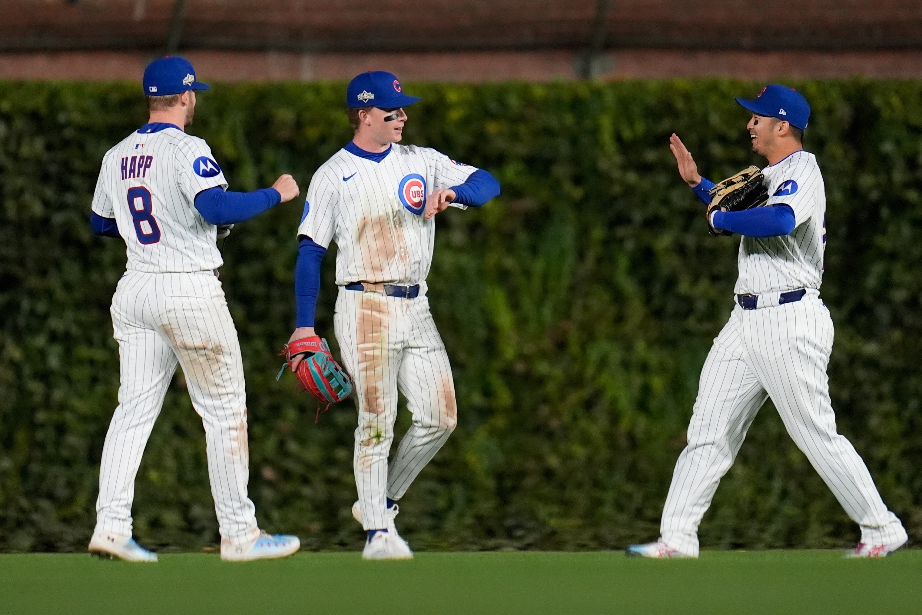 Chicago Cubs' Ian Happ, Pete Crow-Armstrong and Seiya Suzuki celebrate after Game 3 of baseball's National League Division Series against the Milwaukee Brewers Wednesday, Oct. 8, 2025, in Chicago. 