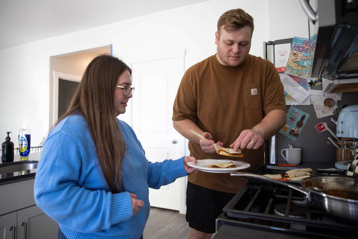 Emma Mendez-Edwards holds a plate for her husband, Bryan Edwards, to place quesadillas on at their home in Heber City on Saturday.