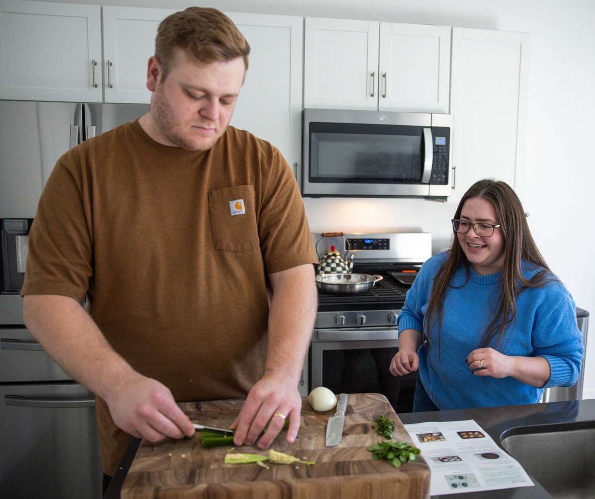 Bryan Edwards, left, and his wife, Emma Mendez-Edwards, make dinner at their home in Heber City on Saturday.
