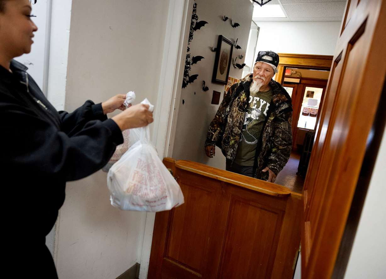 Volunteer Vanessa Carmona brings groceries to Eric Done at Crossroads Urban Center in Salt Lake City on Friday. Food insecurity, especially in Salt Lake City, is greater than ever.