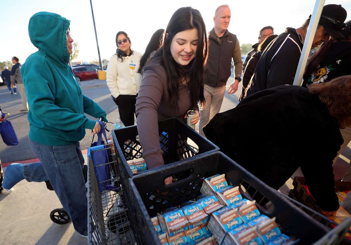 Ashlie King reaches for free milk during a grand reopening ceremony outside of Walmart in West Valley City on Friday.