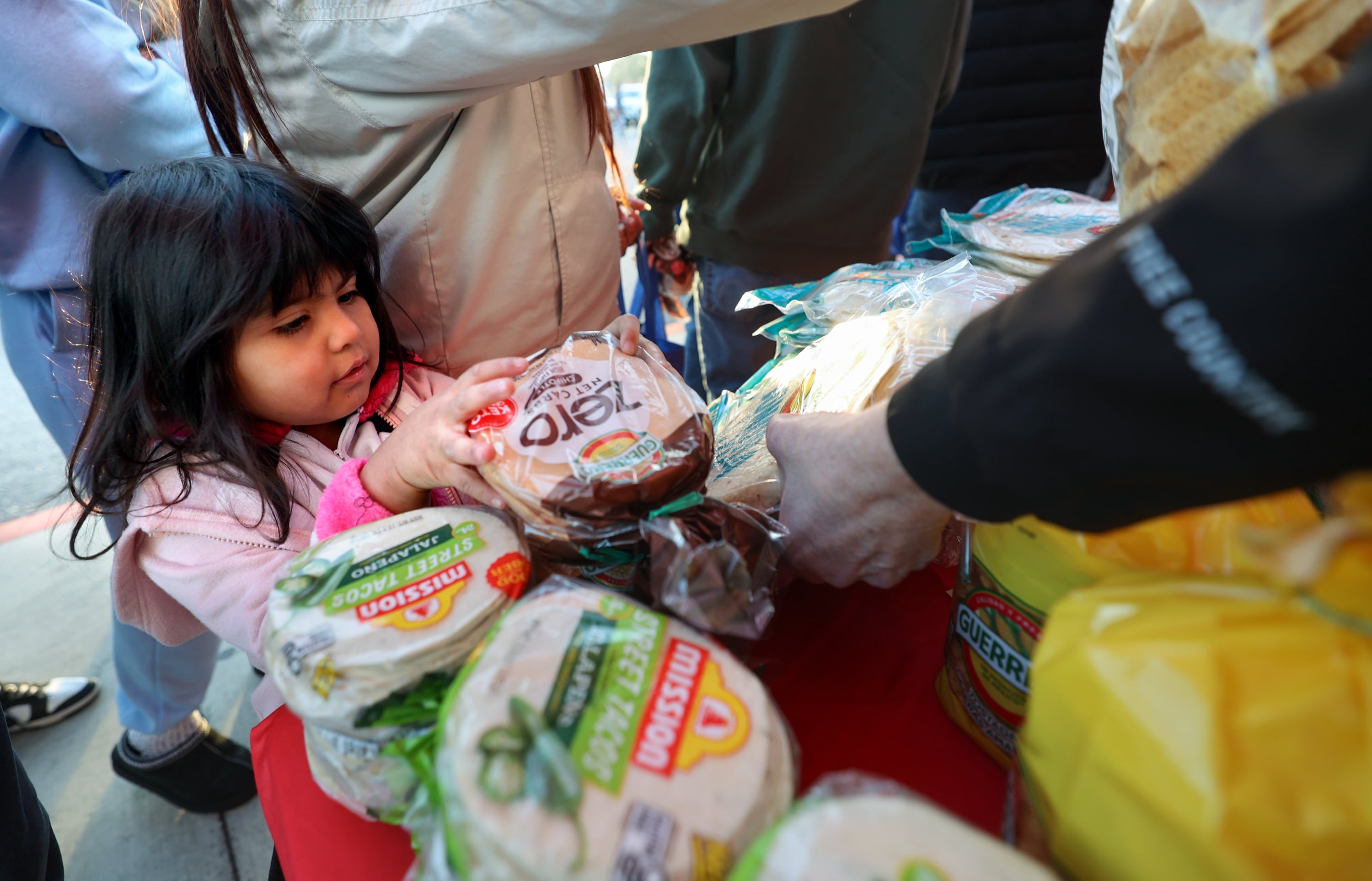 Gloria Ramirez picks out free tortillas during a grand reopening ceremony outside of Walmart in West Valley City on Friday.