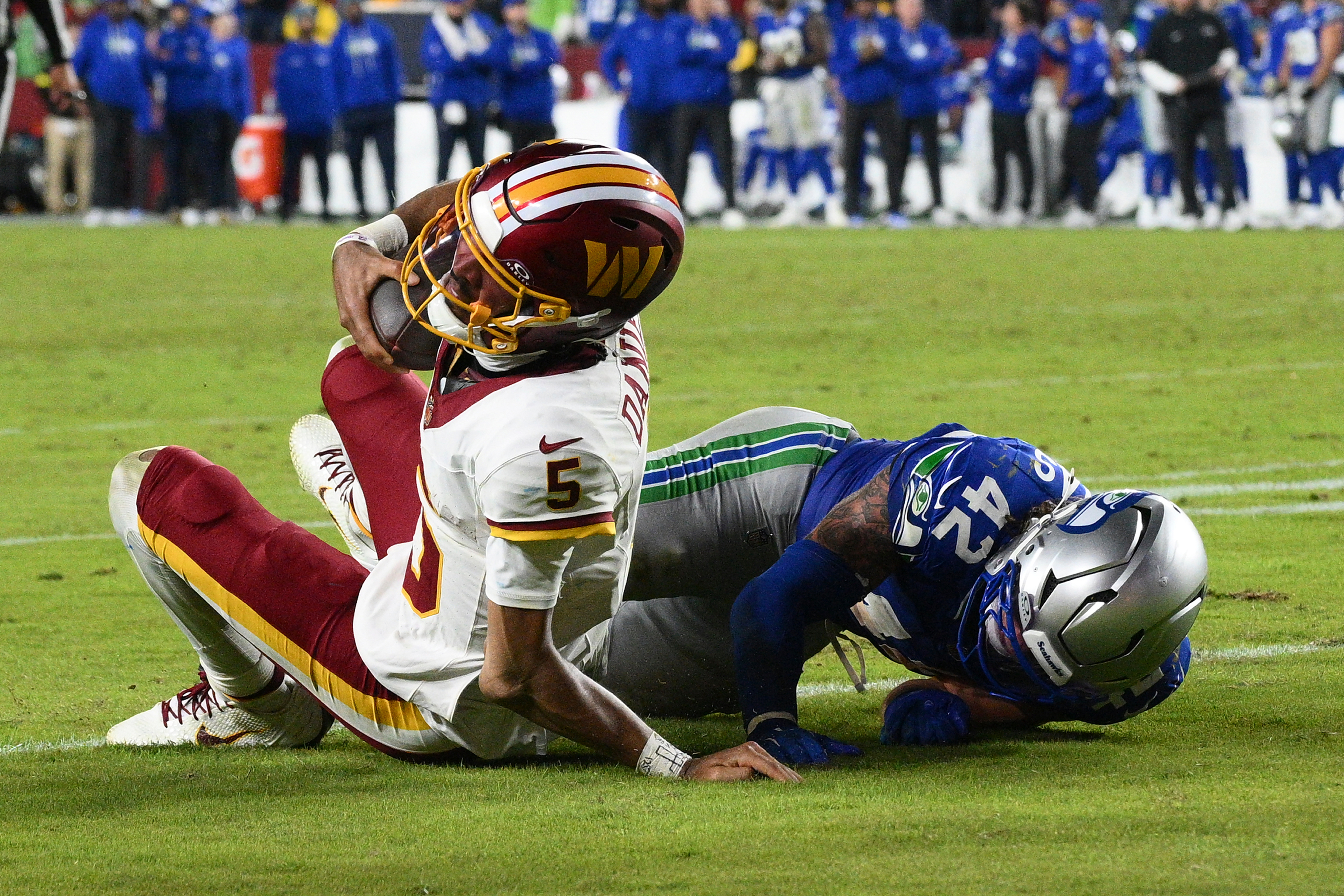 Washington Commanders quarterback Jayden Daniels (5) injures his arm as he is tackled by Seattle Seahawks linebacker Drake Thomas (42) during the second half of an NFL football game, Sunday, Nov. 2, 2025, in Landover, Md. 