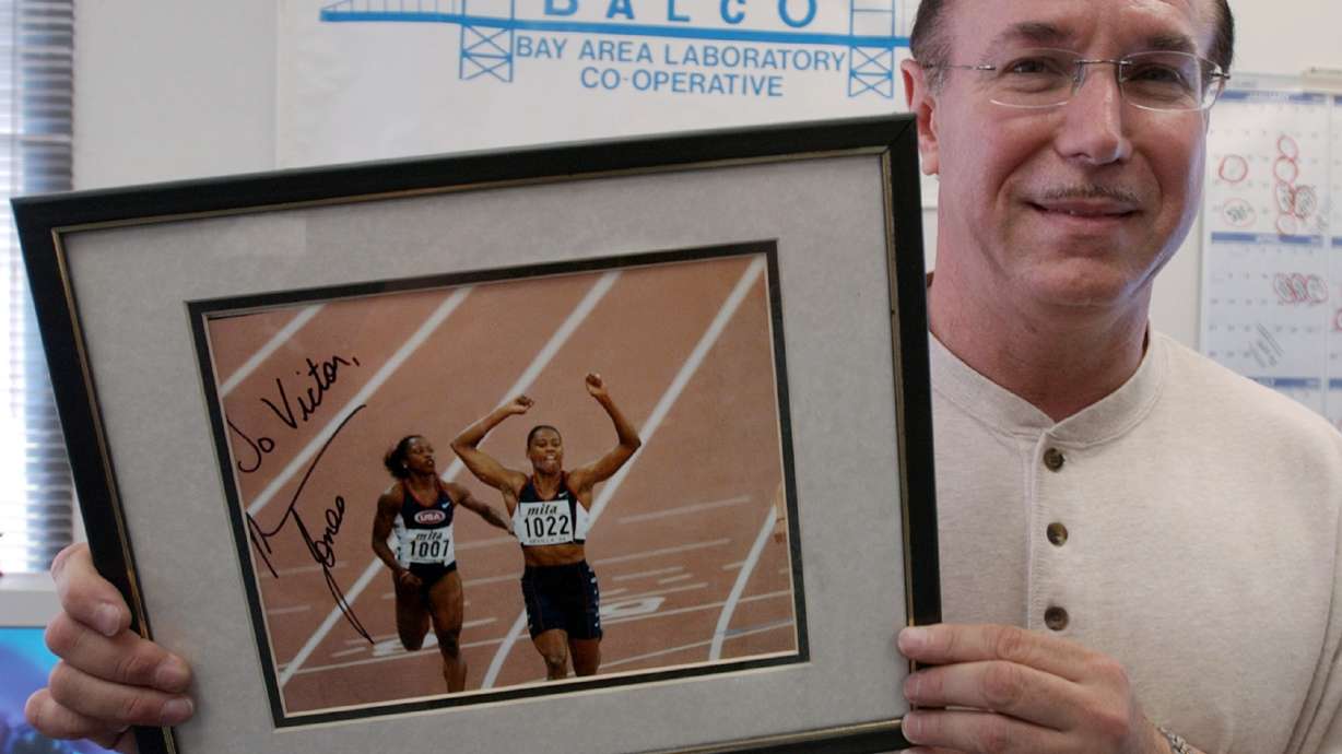 FILE - BALCO founder Victor Conte holds up an autographed photo addressed to Conte of track star Marion Jones in his office in Burlingame, Calif., Oct. 21, 2003.