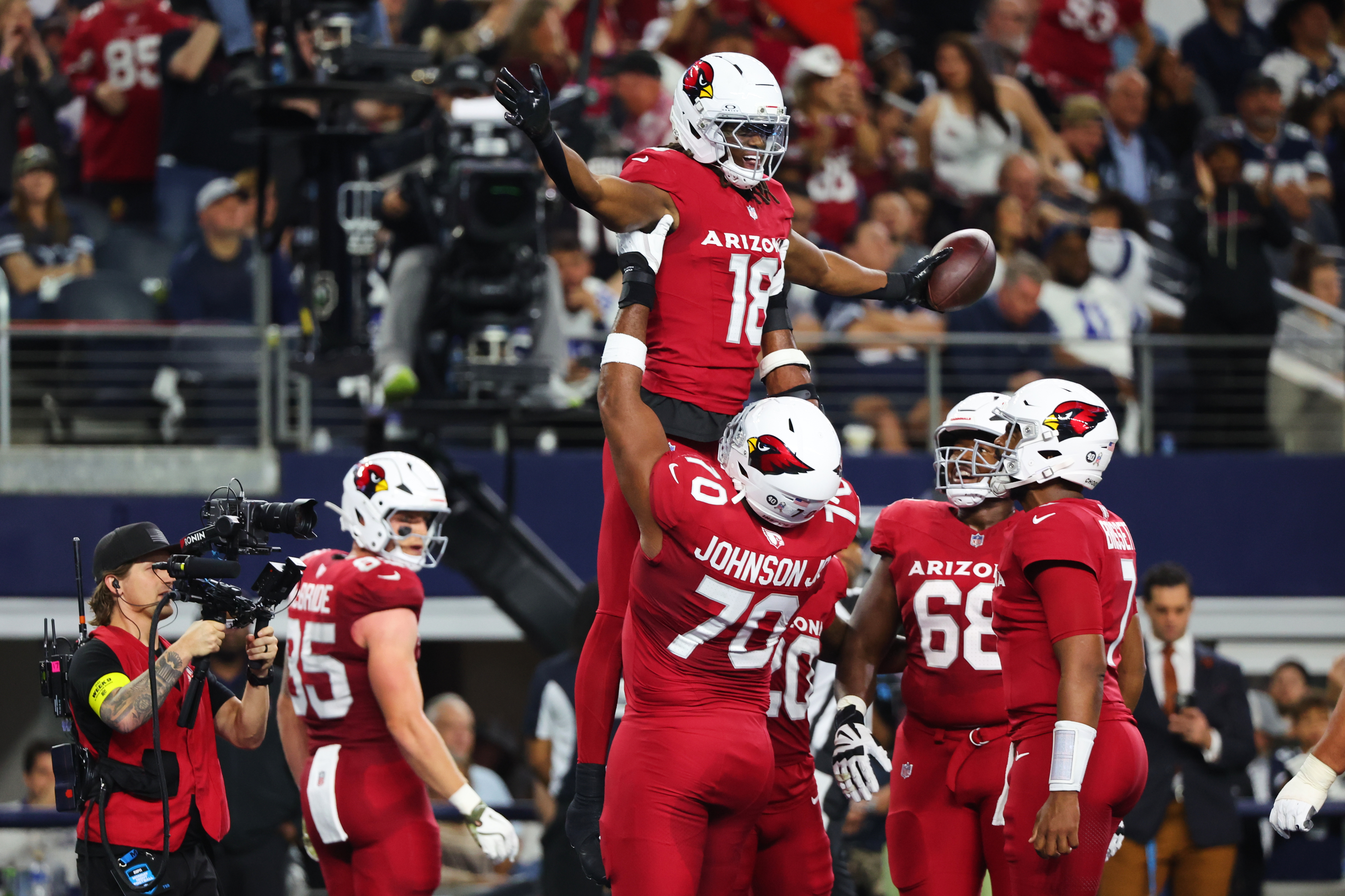 Arizona Cardinals wide receiver Marvin Harrison Jr. (18) is lifted by Paris Johnson Jr. (70) as the two and others celebrate Harrison Jr.s' touchdown catch in the first half of an NFL football game against the Dallas Cowboys Monday, Nov. 3, 2025, in Arlington, Texas.