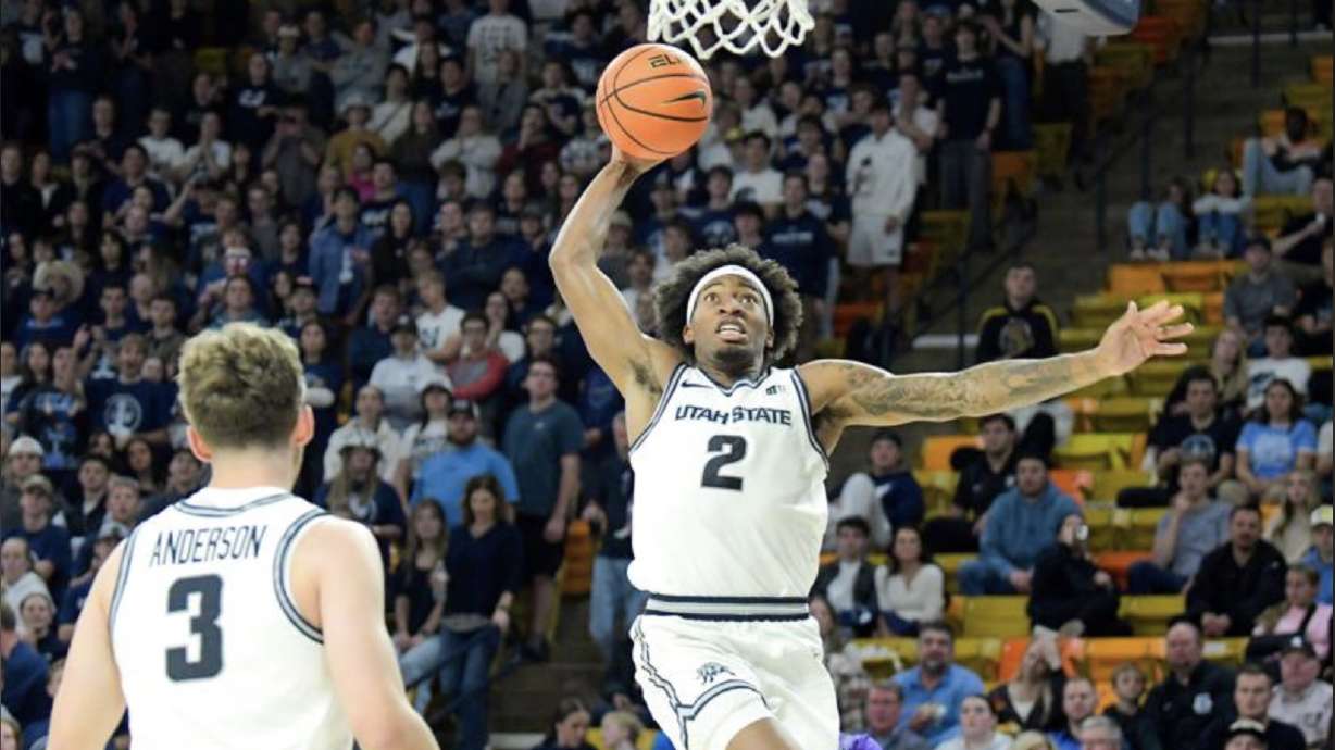 Utah State guard MJ Collins (2) goes up to dunk the ball against Westminster as forward Tucker Anderson (3) looks on in the second half Monday night at the Dee Glen Smith Spectrum. The Aggies won their season opener, 110-54.