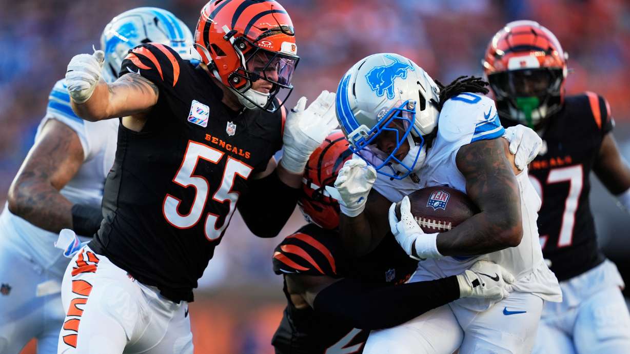 Detroit Lions running back Jahmyr Gibbs (0) runs through Cincinnati Bengals linebacker Logan Wilson (55) for a 20-yard touchdown reception during the second half of an NFL football game Sunday, Oct. 5, 2025, in Cincinnati.