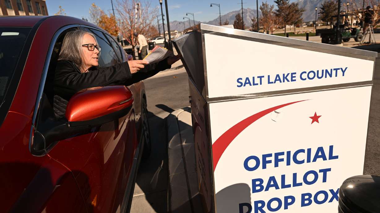 Shelly Stricker, of Herriman, places her ballot into an election drop box at Herriman City Hall on Tuesday.