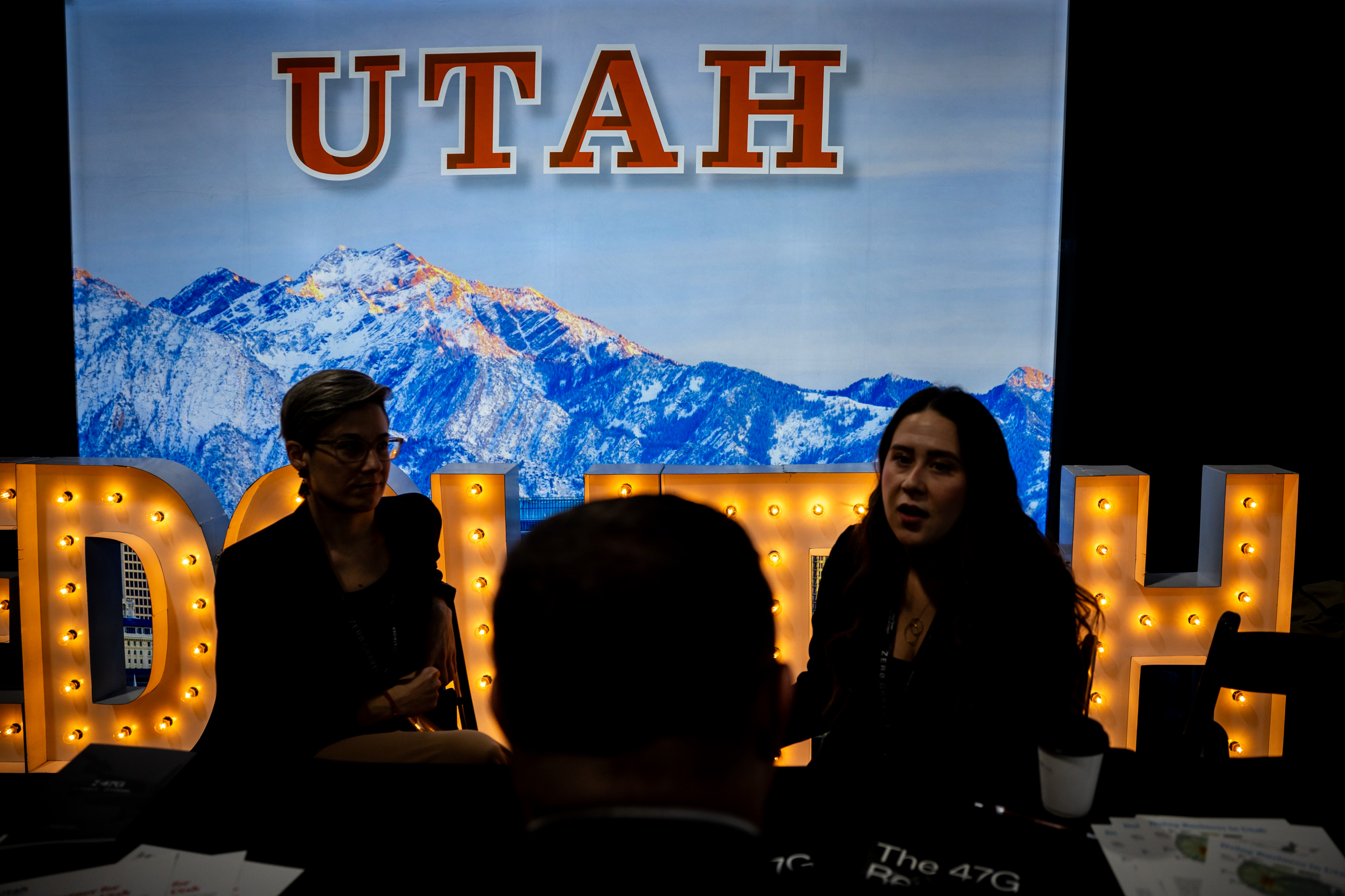 Sara Adelman, vice president of marketing for EDCUtah, Ryan Starks, executive director for EDCUtah, and Justice Russell, marketing and events for EDCUtah, from left, talk at the Economic Development Corporation of Utah booth at the 2025 Zero Gravity Summit hosted by 47G Utah Aerospace & Defense at the Salt Palace Convention Center in Salt Lake City on Tuesday.