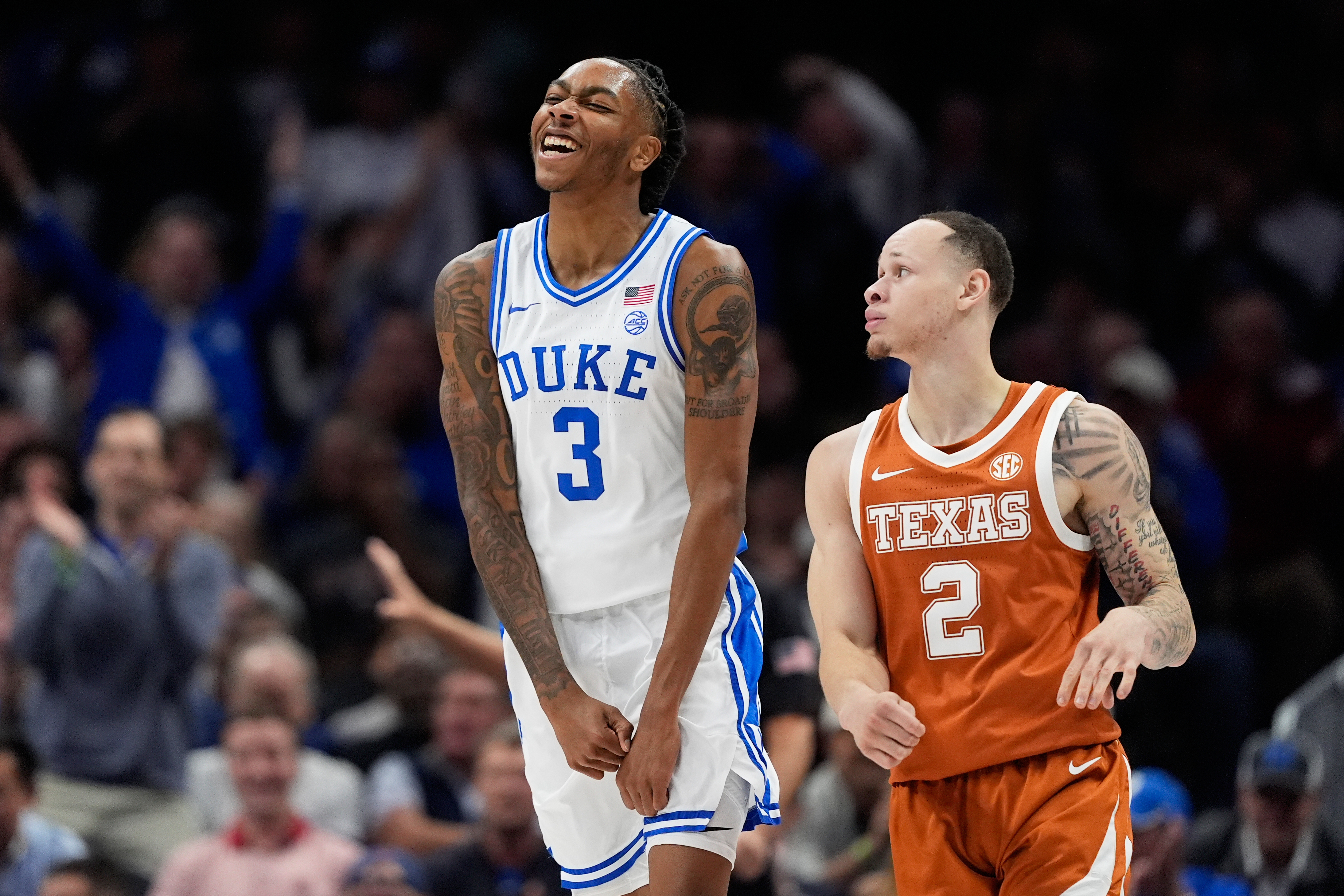 Duke guard Isaiah Evans celebrates after scoring as Texas guard Chendall Weaver looks on during the first half of an NCAA college basketball game, Tuesday, Nov. 4, 2025, in Charlotte, N.C.