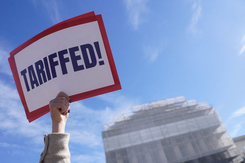 A protester with the Main Street Alliance holds a sign outside the Supreme Court, as its justices are set to hear oral arguments on President Donald Trump's bid to preserve sweeping tariffs after lower courts ruled that Trump overstepped his authority, in Washington, Wednesday. The court heard arguments on Wednesday.