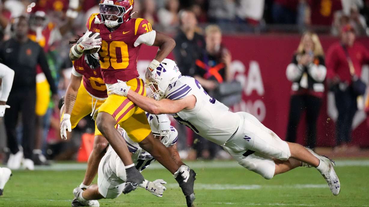 Southern California running back King Miller, left, breaks a tackle by Northwestern linebacker Mac Uihlein during the first half of an NCAA college football game Friday, Nov. 7, 2025, in Los Angeles.