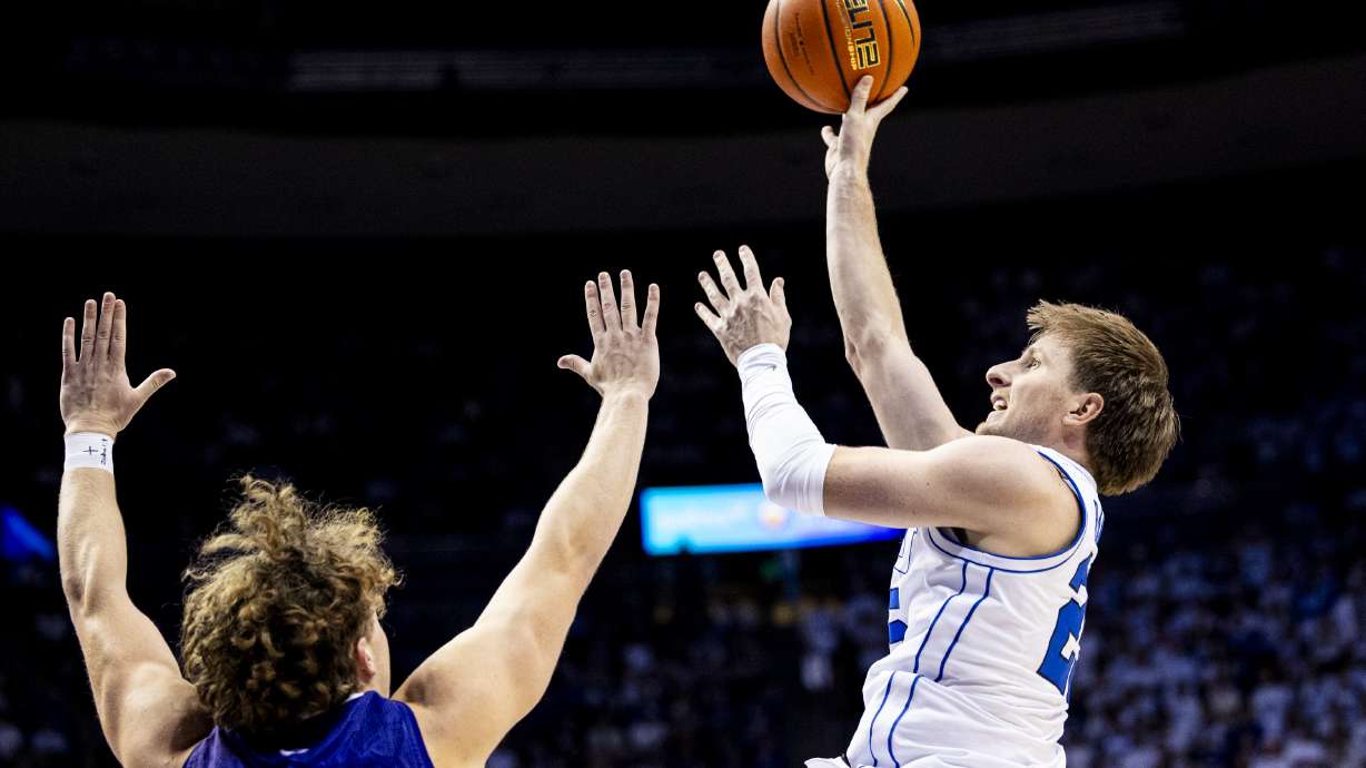 BYU guard Dawson Baker (25) lays the ball up while guarded by Holy Cross forward Will Aljancic (1) during an NCAA men’s basketball game held at the Marriott Center in Provo on Saturday, Nov. 8, 2025.