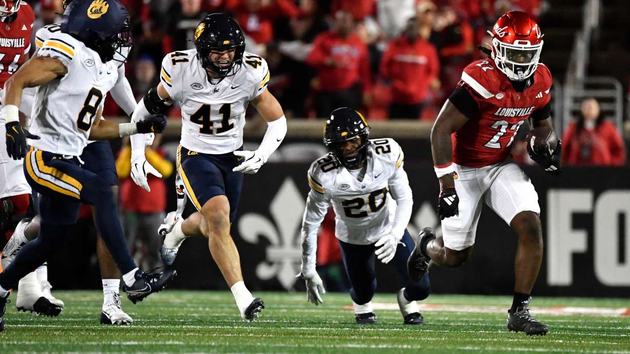 Louisville running back Keyjuan Brown (22) runs from the pursuit of California defensive back Jasiah Wagoner (8), linebacker Luke Ferrelli (41), and defensive back Cam Sidney (20) during the first half of an NCAA college football game in Louisville, Ky., Saturday, Nov. 8, 2025.