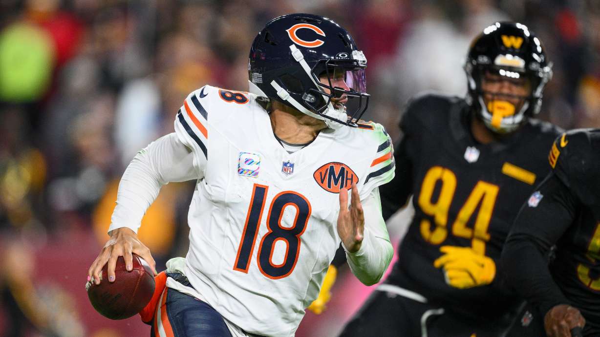 Chicago Bears quarterback Caleb Williams (18) runs away from Washington Commanders nose tackle Daron Payne (94) during the second half of an NFL football game Monday, Oct. 13, 2025, in Landover, Md.