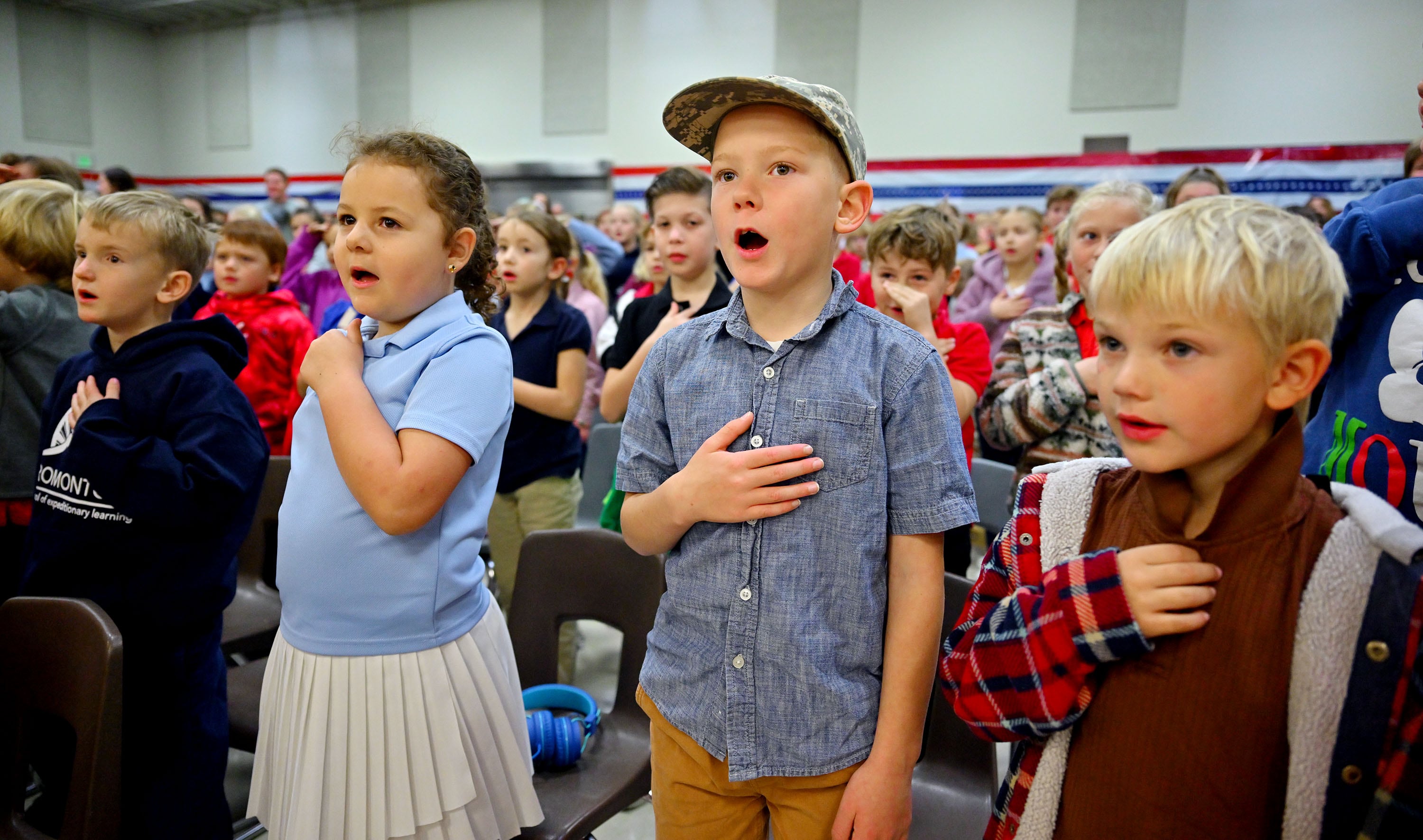 Gordon Malin, Arianie Wagstaff, Miley Bagley and Henry Hawley stand with other students to recite the Pledge of Allegiance as Utah Rep. Blake Moore and Jennie Taylor, the Gold Star widow of Utah Army National Guard Maj. Brent Taylor, who was killed in action in Afghanistan in November of 2018, gather at Promontory School of Expeditionary Learning to honor local service members at an assembly in Perry on Monday.