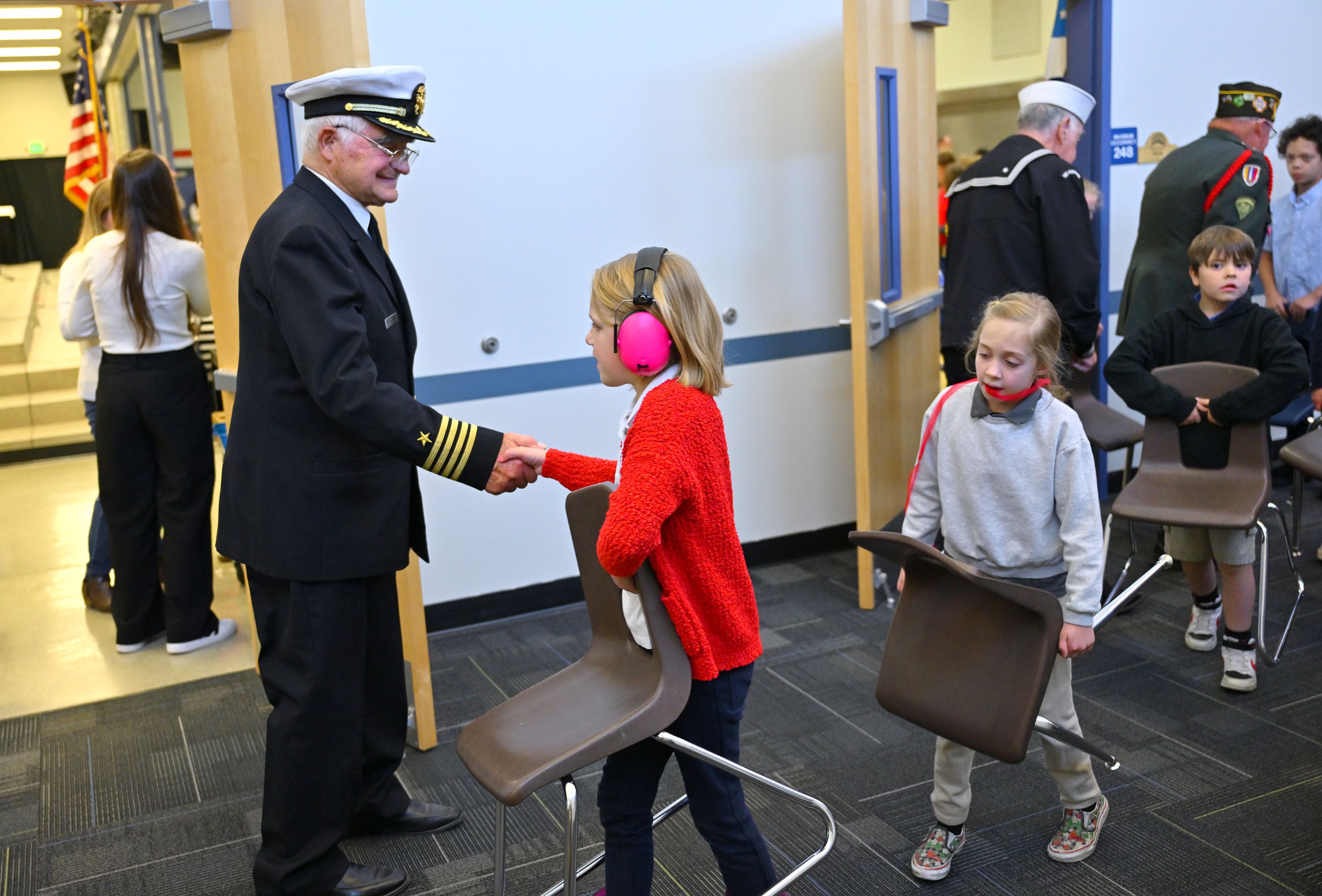 James Whiting, retired U. S. Coast Guard, shakes hands with students after they took part in a program listening to Utah Rep. Blake Moore and Jennie Taylor, the Gold Star widow of Utah Army National Guard Maj. Brent Taylor, who was killed in action in Afghanistan in November of 2018, at Promontory School of Expeditionary Learning to honor local service members at an assembly in Perry on Monday.