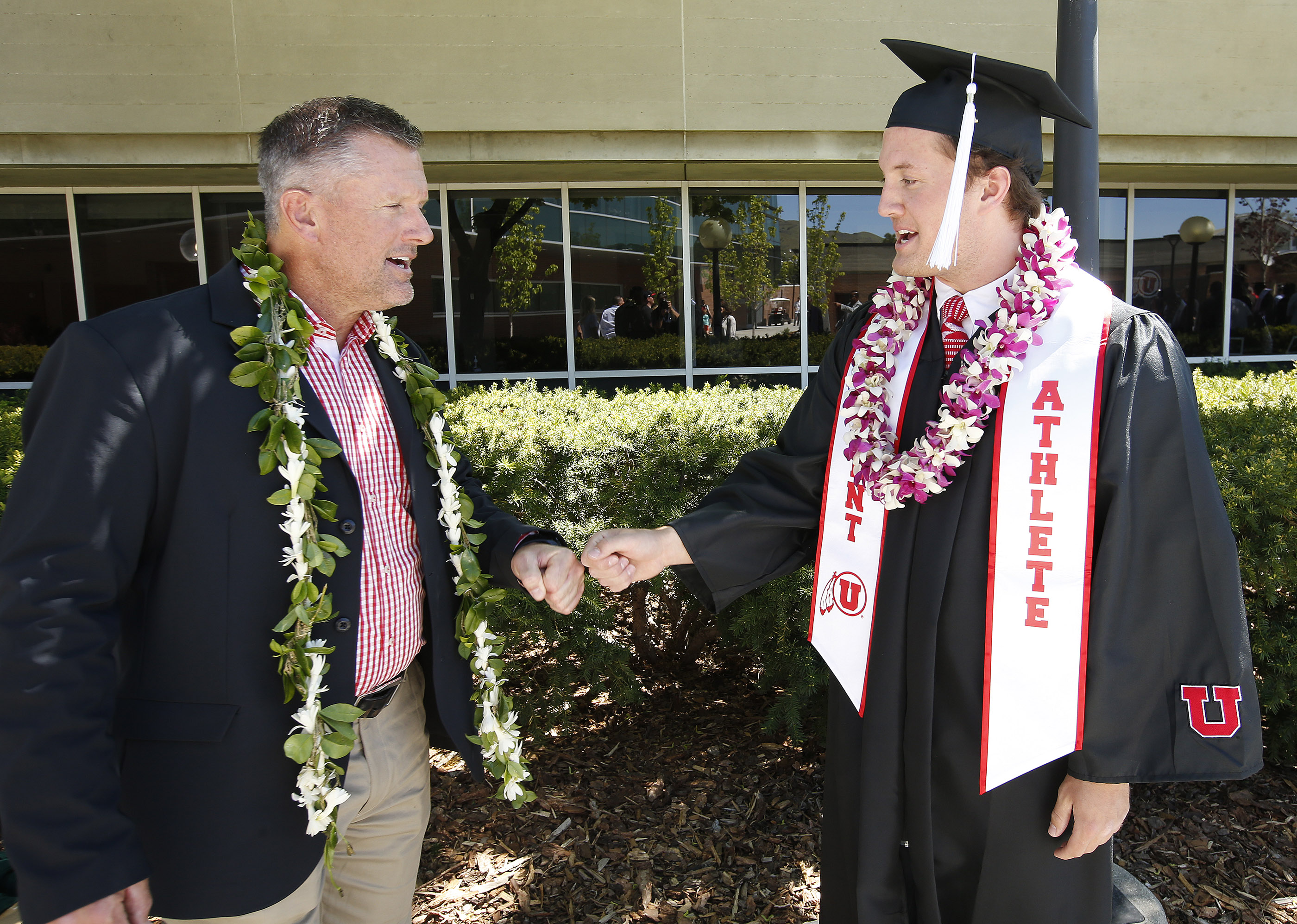 Coach Kyle Whittingham talks with his son Alex as University of Utah football team members gather during University of Utah graduation in Salt Lake City on Friday, May 5, 2017.