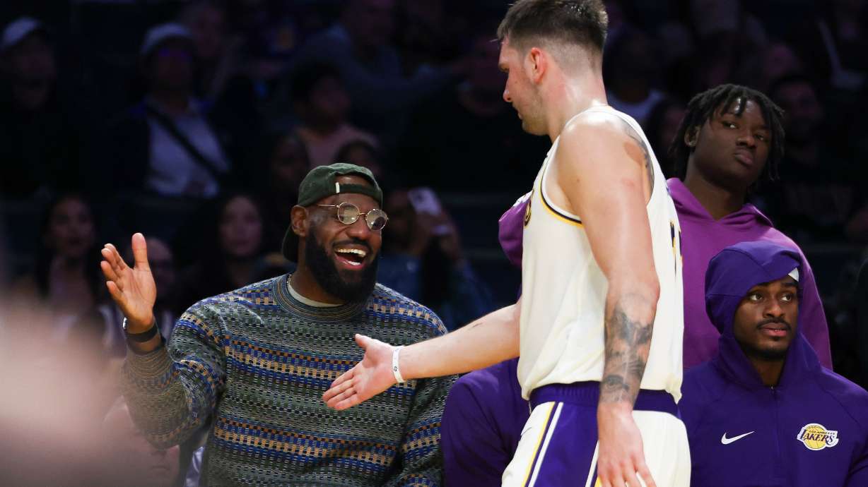 Los Angeles Lakers forward LeBron James, left, and guard Luka Doncic, center, celebrate as forward Jarred Vanderbilt, right, looks on during the second half of an NBA basketball game against the Miami Heat, Sunday, Nov. 2, 2025, in Los Angeles.