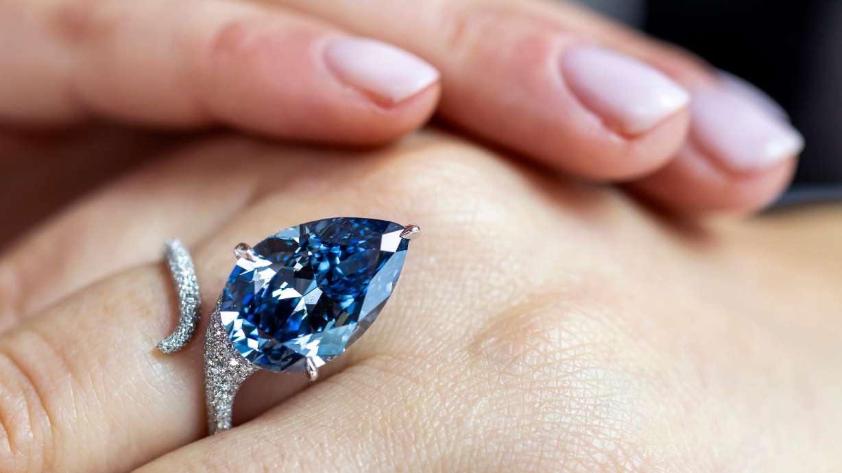 A Christie's employee displays the Mellon Blue, a blue pear-shaped diamond of 9.51 carats, during a preview at Christie's in Geneva, Switzerland, Friday, ahead of an auction. It sold for $25.6 million on Tuesday.