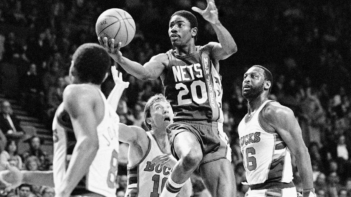 FILE - New Jersey Nets; Michael Ray Richardson (20) drives to the basket past Milwaukee Bucks' Mike Dunleavy (10) and Bob Lanier (16) during the first quarter of an NBA basketball playoff game, May 8, 1984, Milwaukee.