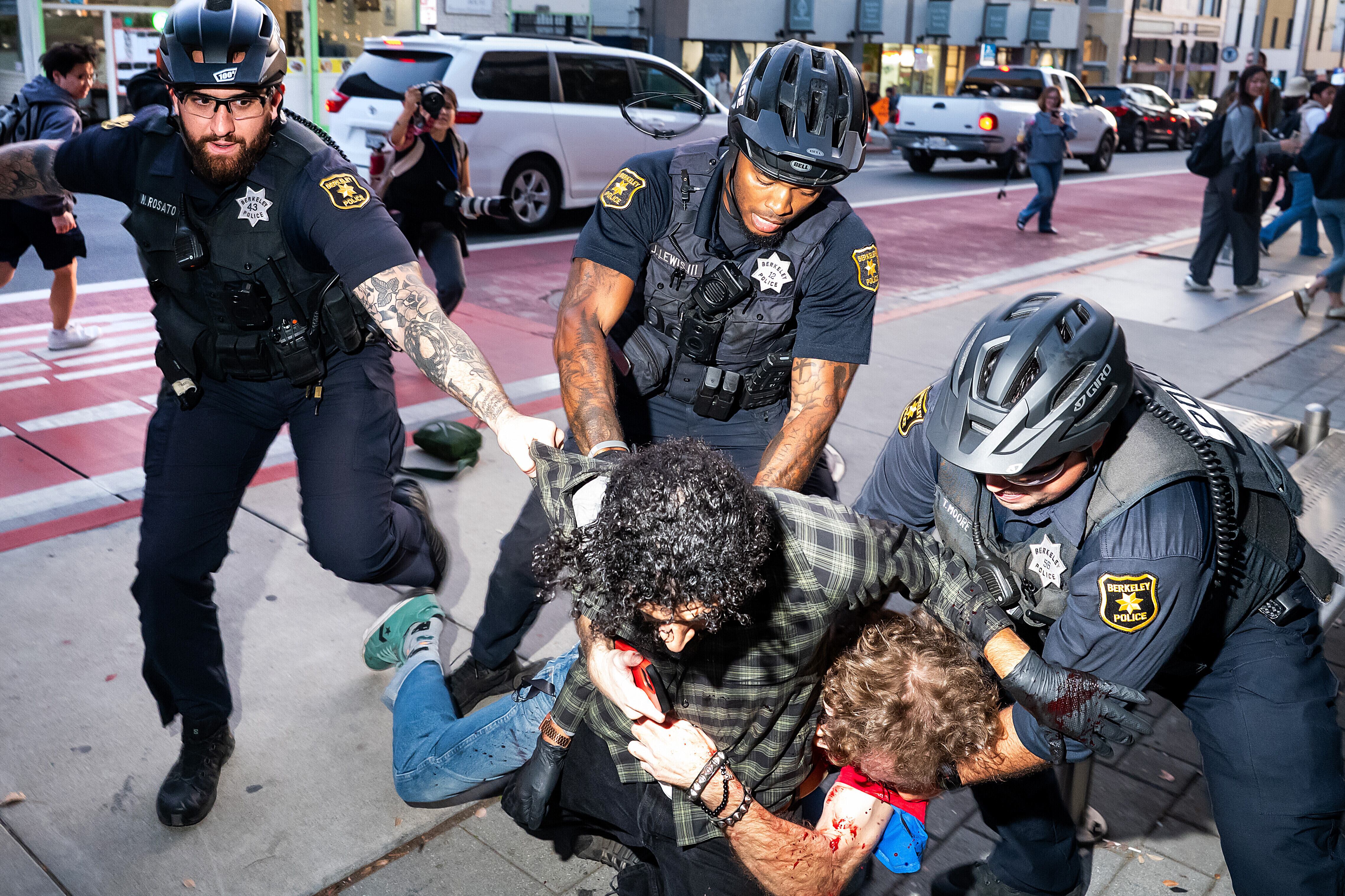 Police officers separate two men outside a Turning Point USA event at the University of California, Berkeley, on Monday, in Berkeley, Calif. Protesters gathered outside the event that took place exactly two months after conservative activist and Turning Point USA co-founder Charlie Kirk was assassinated in Utah.