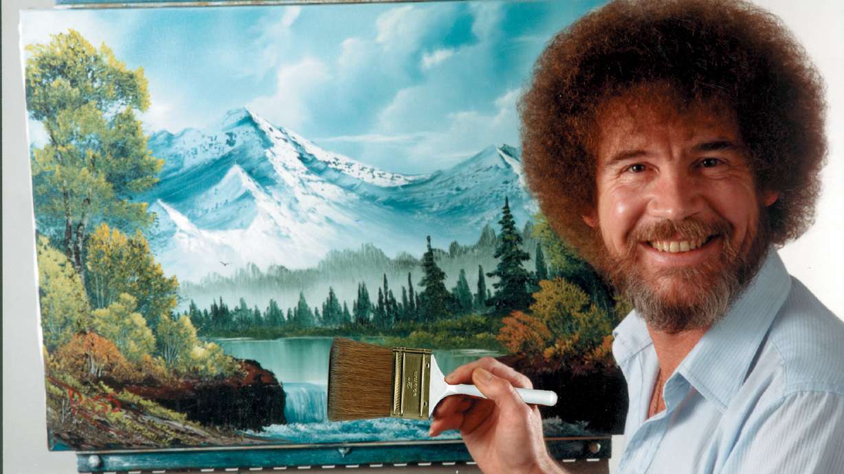 In this undated photo provided by Bob Ross Inc., Bob Ross poses for a photo in front of one of his paintings. Three of Ross's paintings sold for over $600,000 on Tuesday to benefit public TV stations.