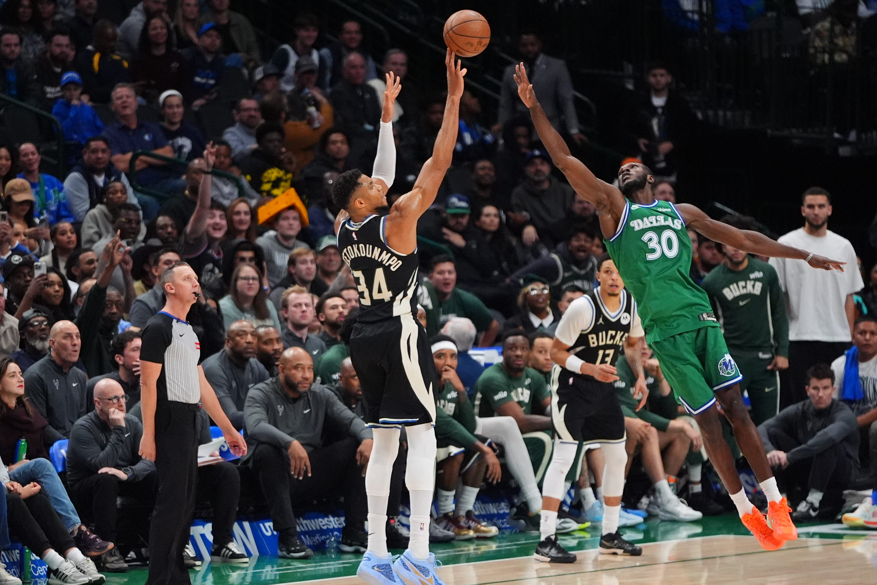 Milwaukee Bucks forward Giannis Antetokounmpo (34) shoots a three-pointer against Dallas Mavericks center Moussa Cisse (30) during the second half of an NBA basketball game in Dallas, Monday, Nov. 10, 2025.