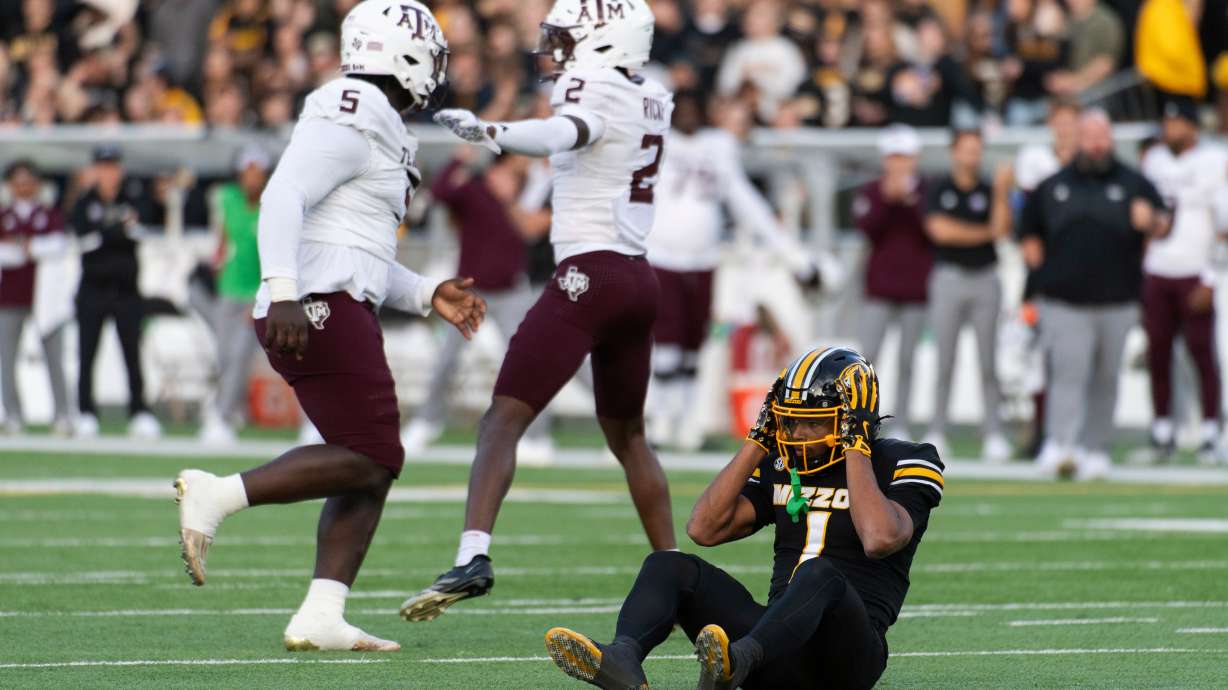 Missouri wide receiver Donovan Olugbode (1) grabs his helmet after missing a fourth-down reception as Texas A&M defensive tackle DJ Hicks (5) and cornerback Dezz Ricks (2) celebrate during the first half an NCAA college football game Saturday, Nov. 8, 2025, in Columbia, Mo.