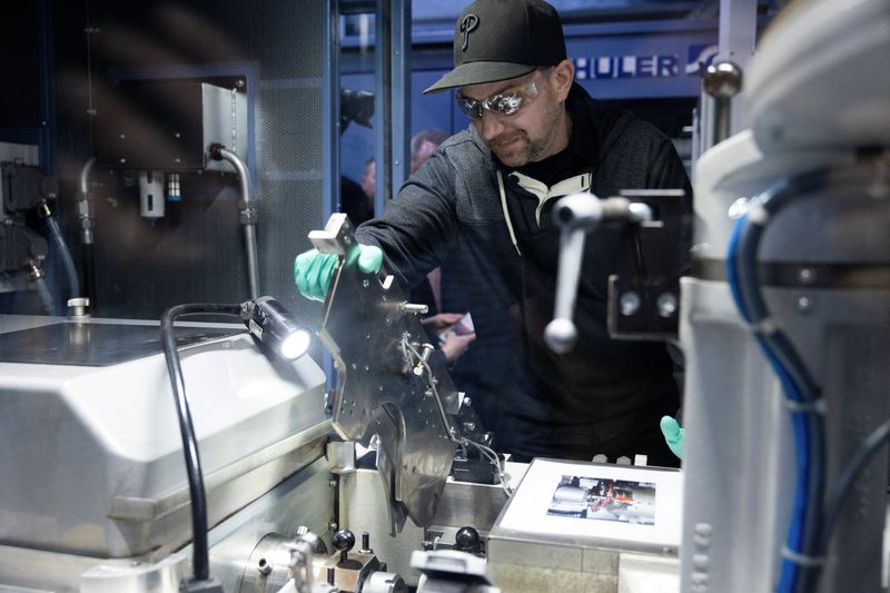 A U.S. Mint employee places the last penny to be struck into a coining press, ending 232 years of penny production in the United States, at the United States Mint in Philadelphia, Wednesday. The last five pennies struck will be auctioned off, officials said.