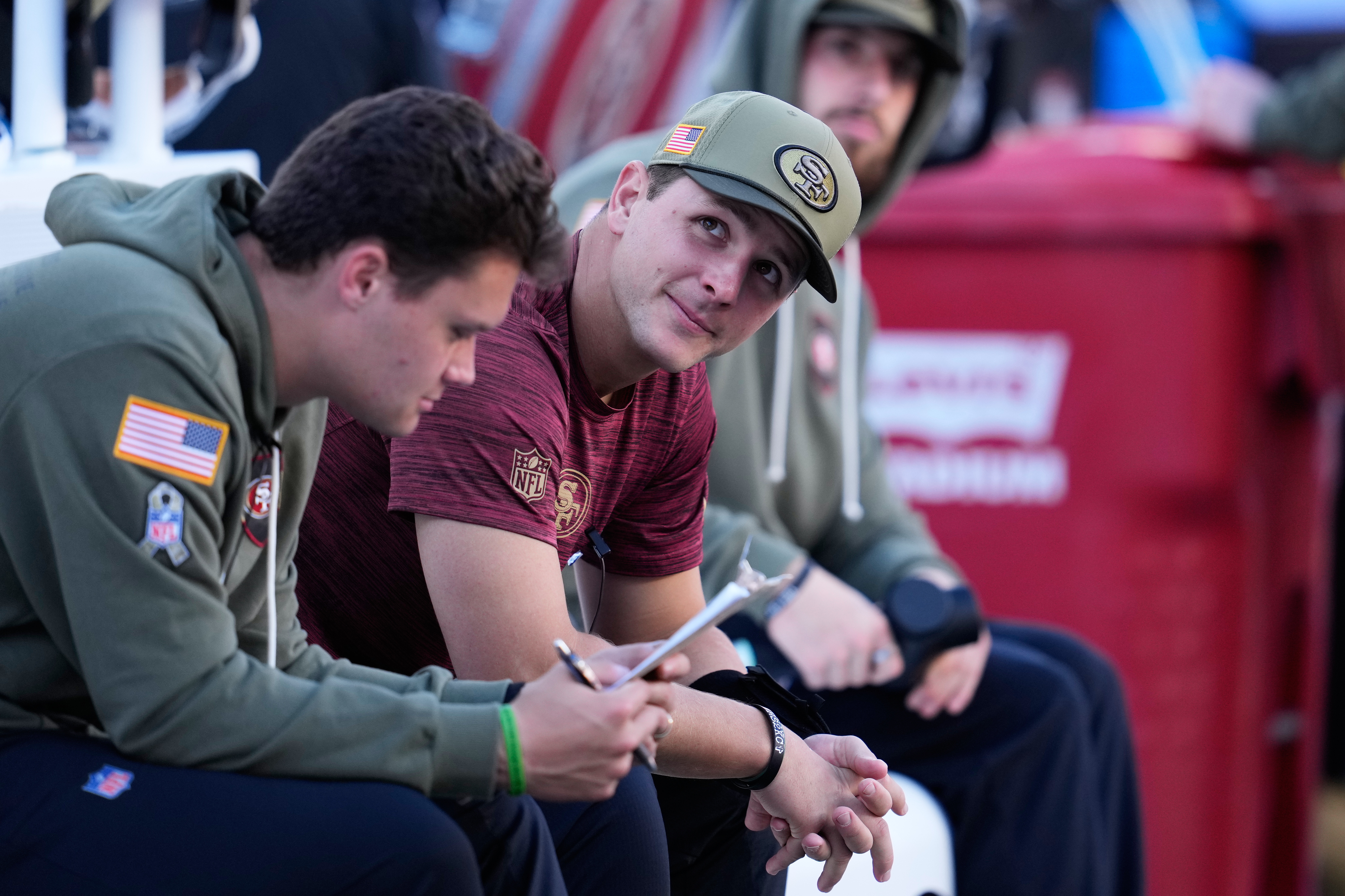 Injured San Francisco 49ers quarterback Brock Purdy, middle, sits on the bench during the first half of an NFL football game against the Los Angeles Rams in Santa Clara, Calif., Sunday, Nov. 9, 2025.