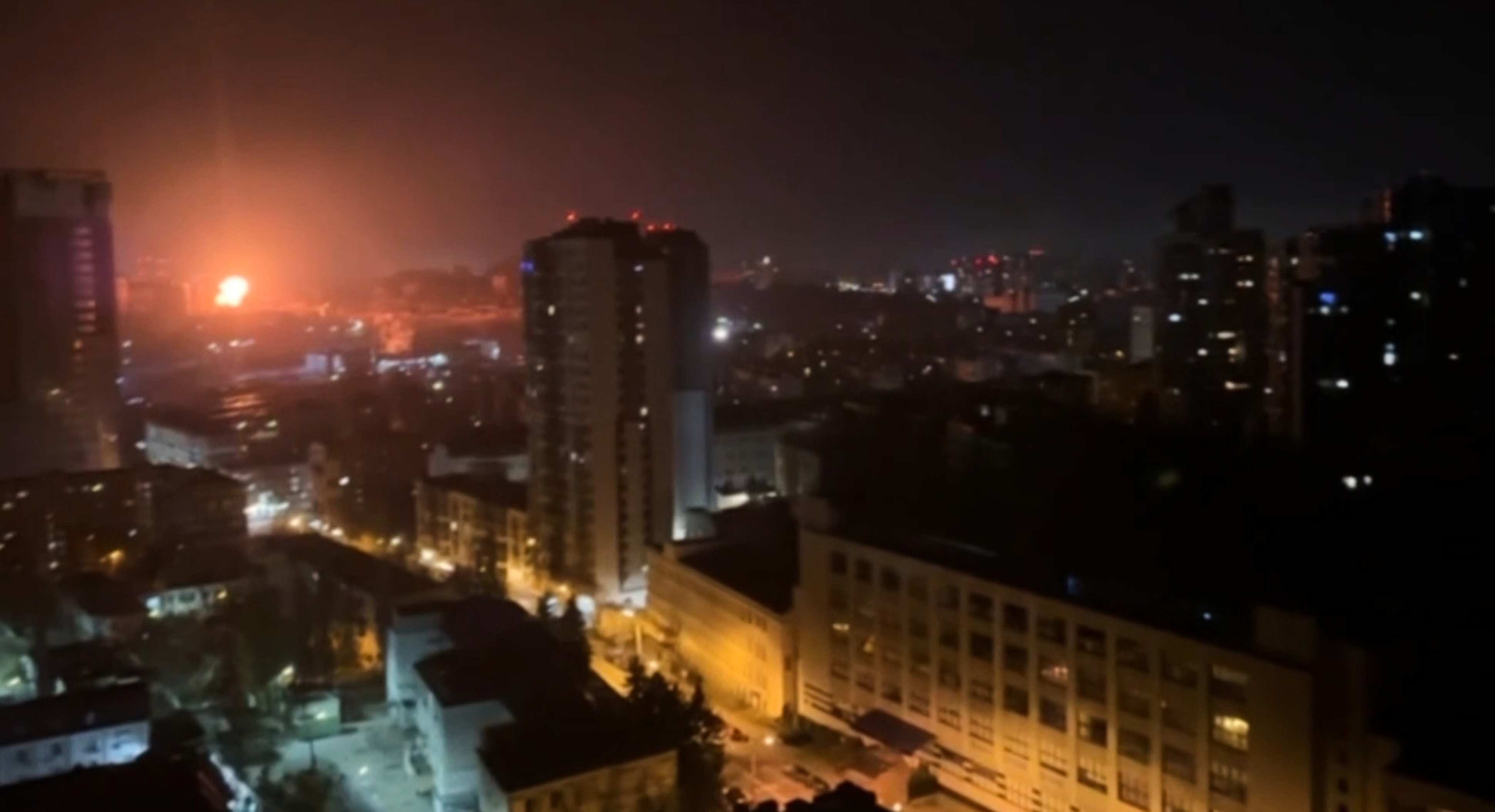 In this image taken from video, an explosion is seen in the distance as a Russian attack targets Ukraine's Kyiv region on Friday. Russia launched a major missile and drone attack on Kyiv, killing six people and wounding at least 35, including a pregnant woman.