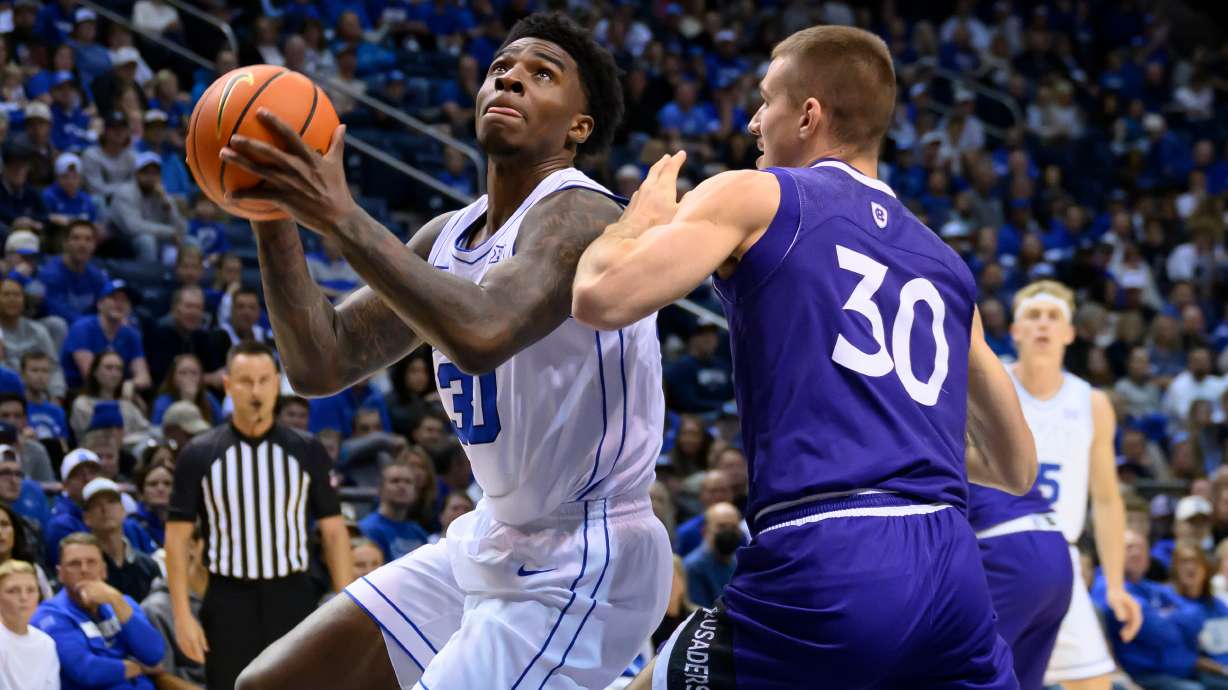 BYU forward Kennard Davis Jr. drives to the basket guarded by Holy Cross guard Joe Nugent (30) during the first half of an NCAA college basketball game, Saturday, Nov. 8, 2025, in Provo, Utah.