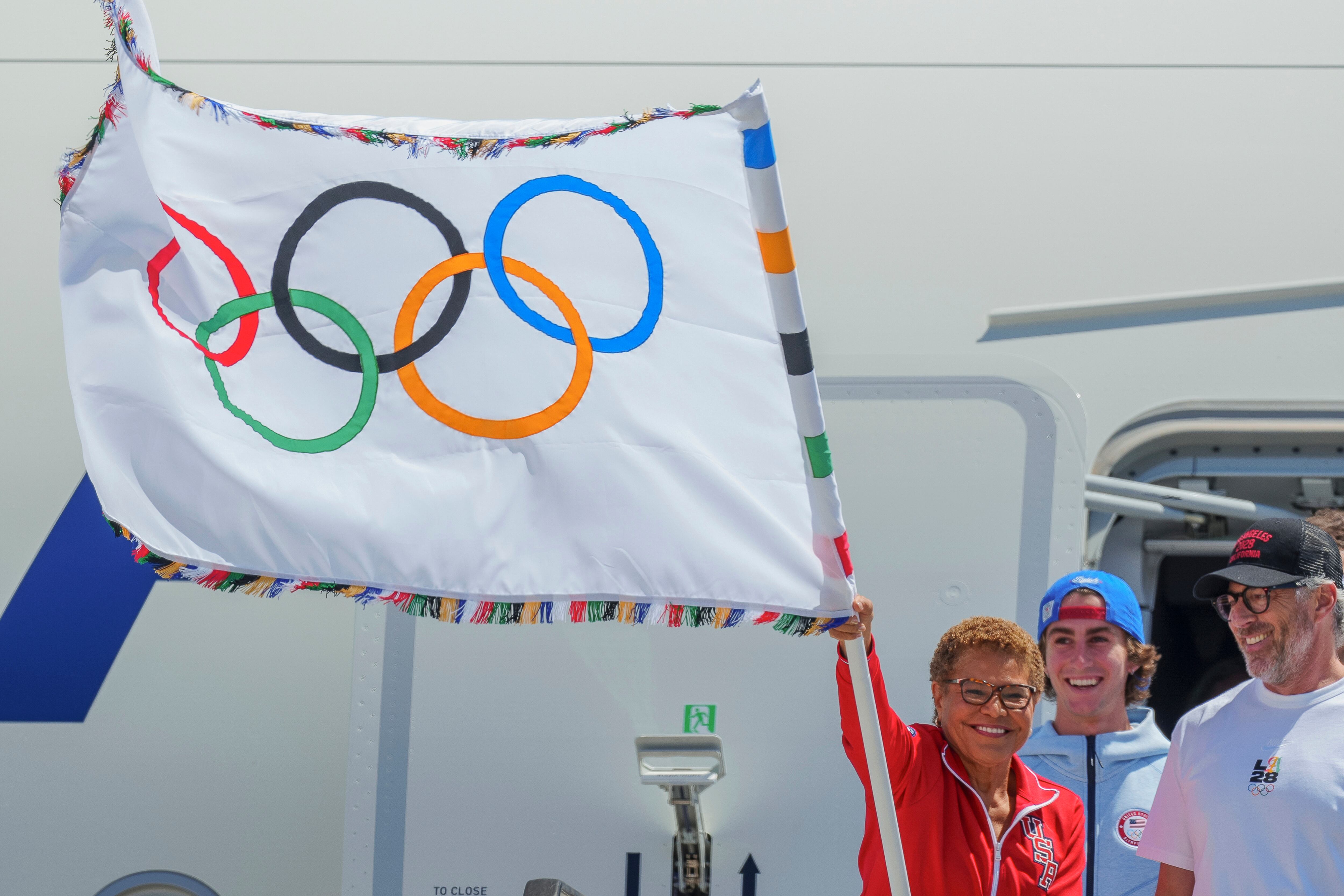 Los Angeles Mayor Karen Bass holds the official Olympic flag at Los Angeles International Airport on Aug. 12, 2024. The volunteer program for the 2028 Summer Olympics began last week.